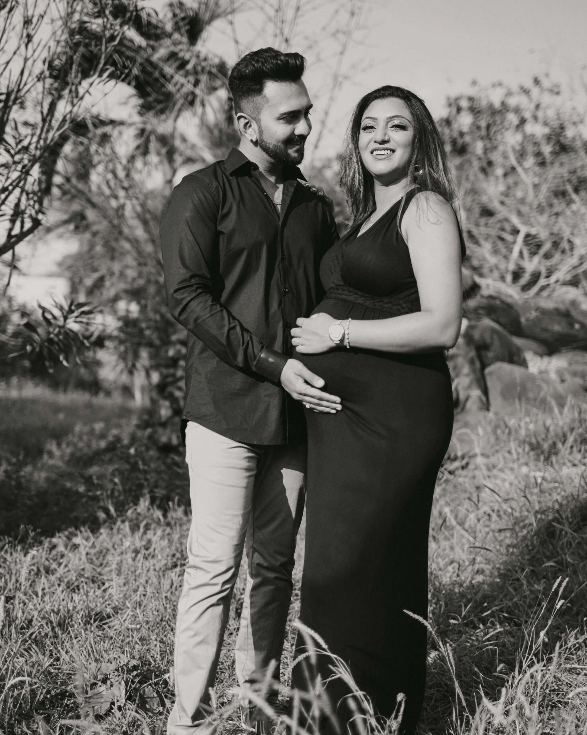 Authentic pregnancy portrait in black & white, mother seated in floral dress, Malindi.