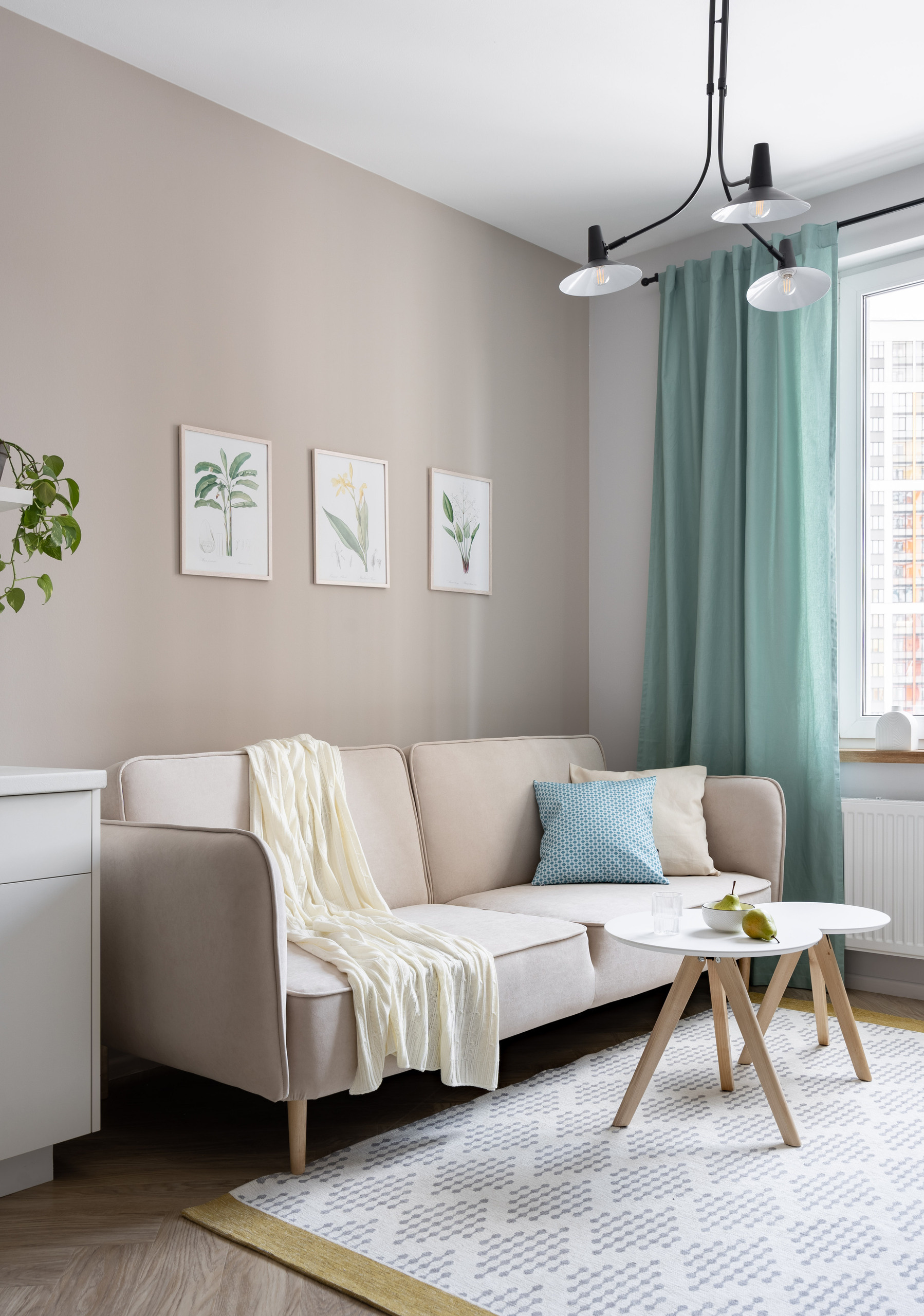 Интерьер гостиной с диваном, креслом и журнальным столиком в пастельных тонах.