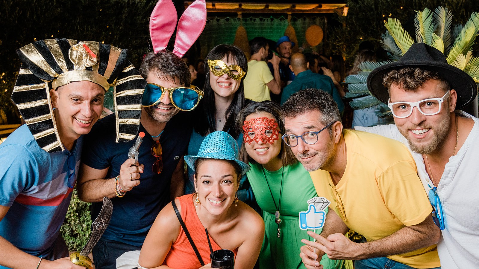 Gruppo di persone che ridono al servizio photo booth con stampa immediata ad una festa, con props per fare le foto buffe