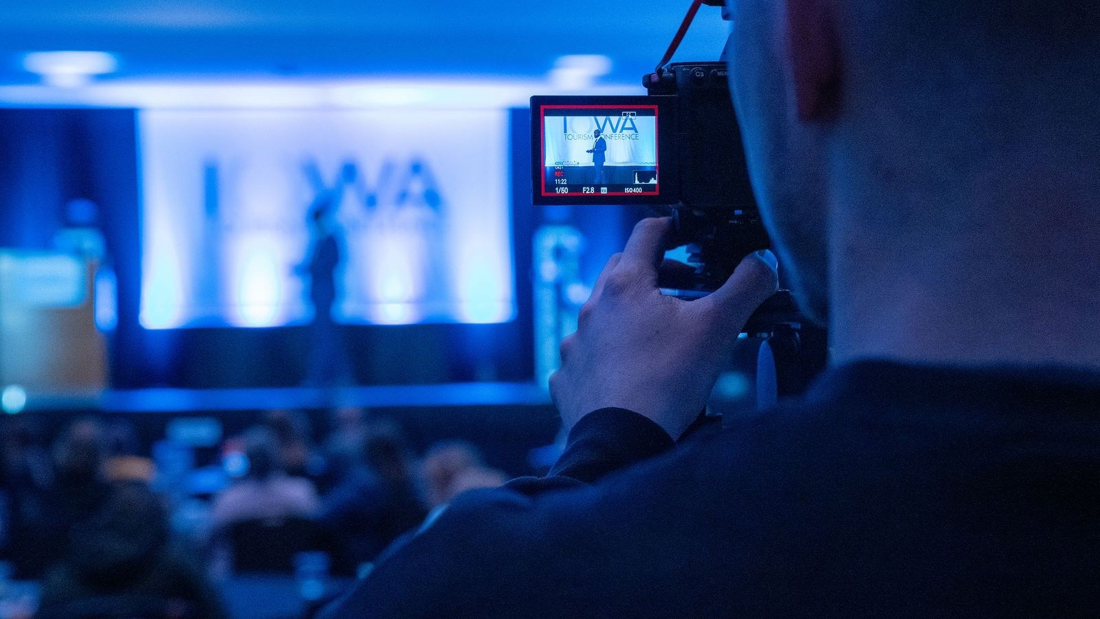Videographer recording a speaker during a professionally produced corporate event