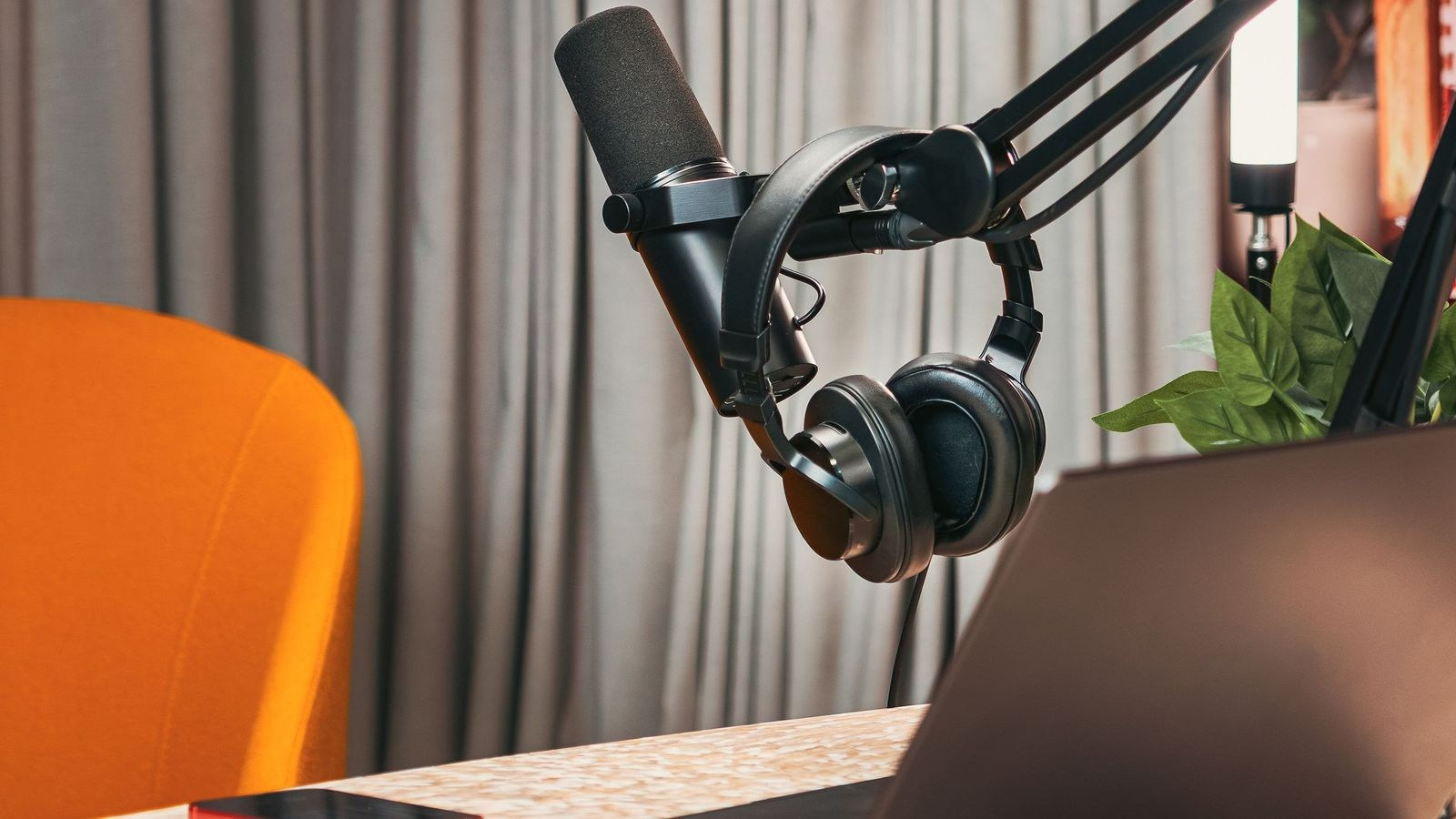 Professional podcast microphone, headphones and laptop prepared for a recording session