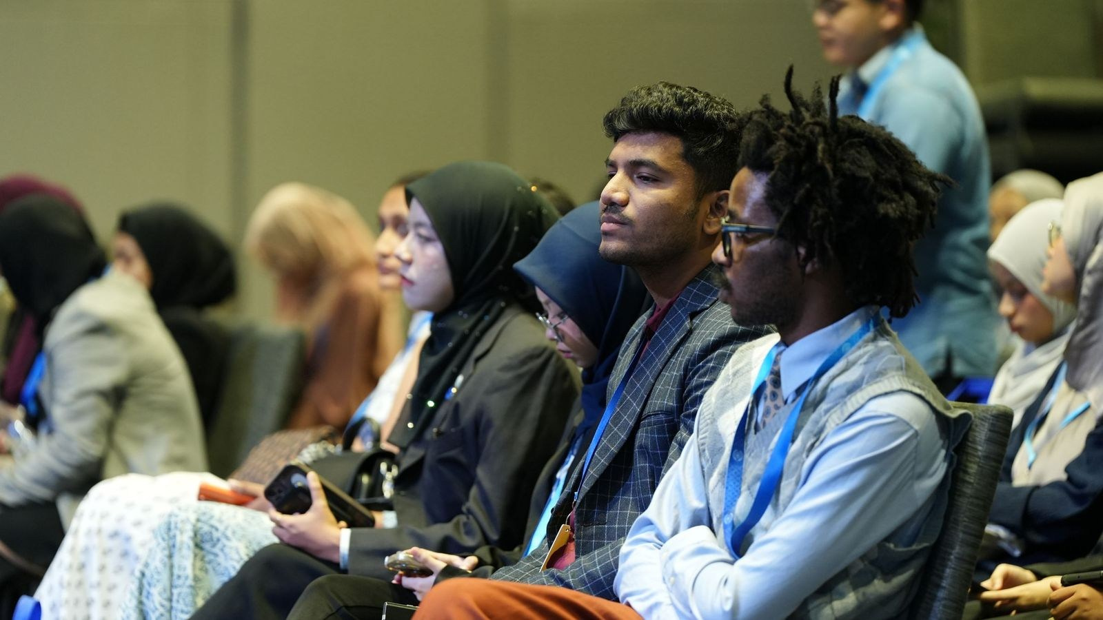 Corporate conference attendees watching a presentation during a private business event