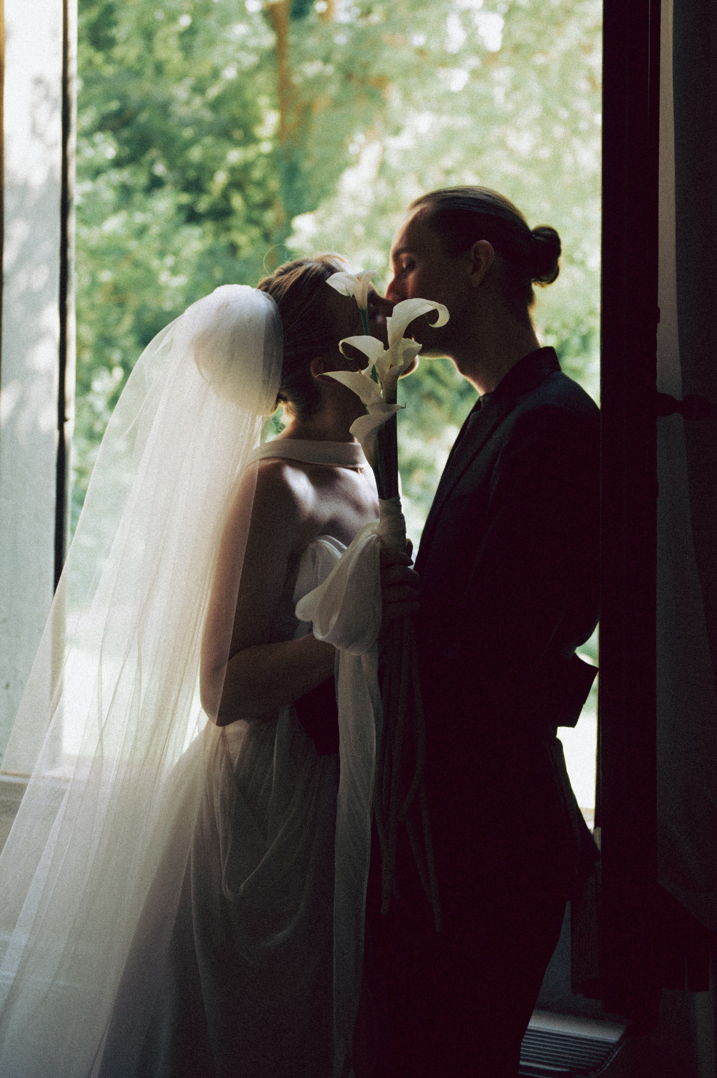 Bride and groom sharing an intimate moment by a window on their wedding day in Italy. 10 questions to ask before booking your wedding photographer in Italy