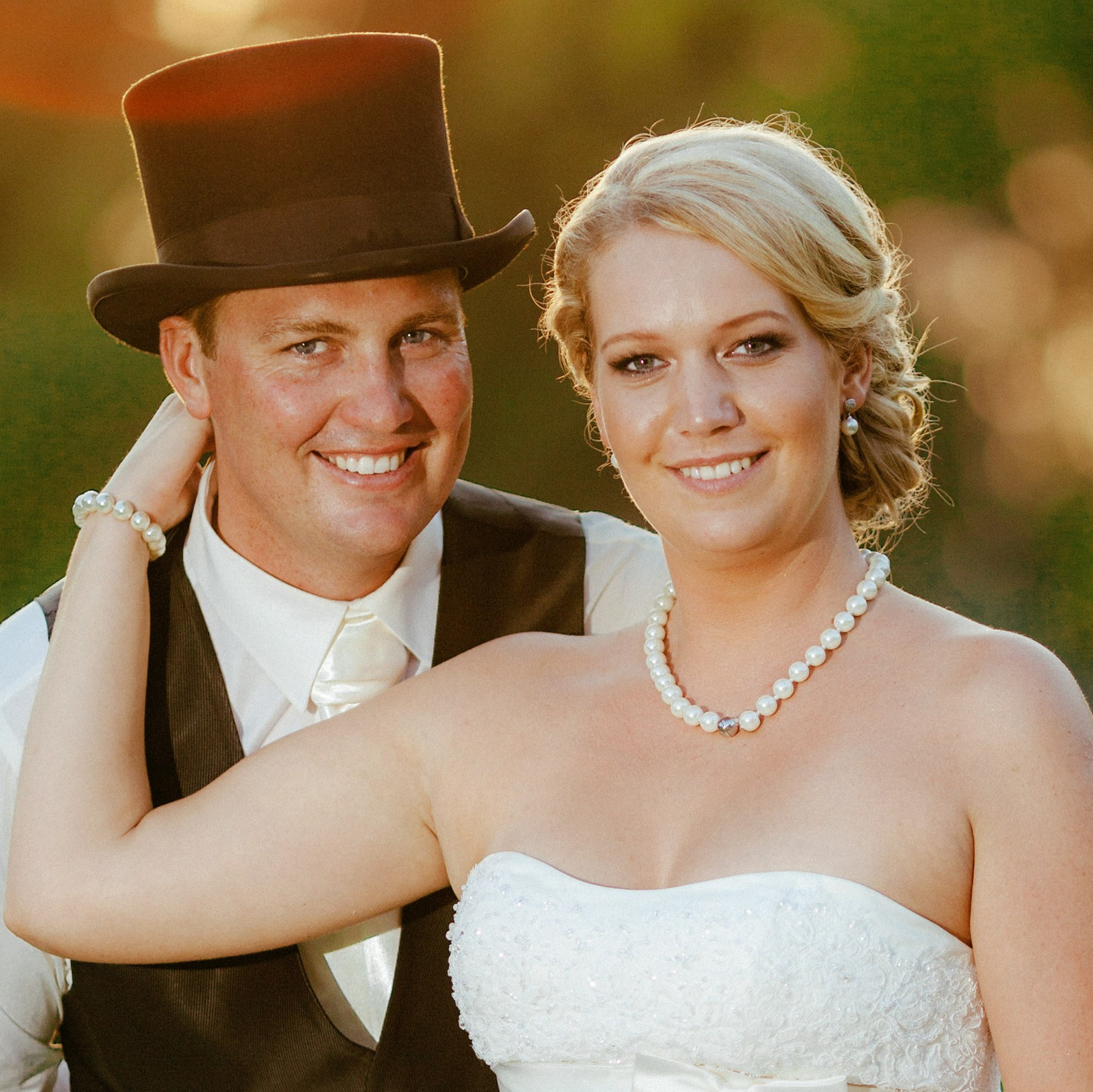 Red-haired bride holding her flowing veil aloft smiles seductively to her bouquet holding groom as he leans back against a railing in appreciation at the Vrtba Garden in Prague. 