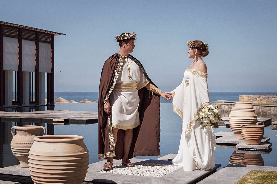 Молодожены в образе древнегреческих богов на фоне моря на Крите. Фотограф, свадьба в Греции.
