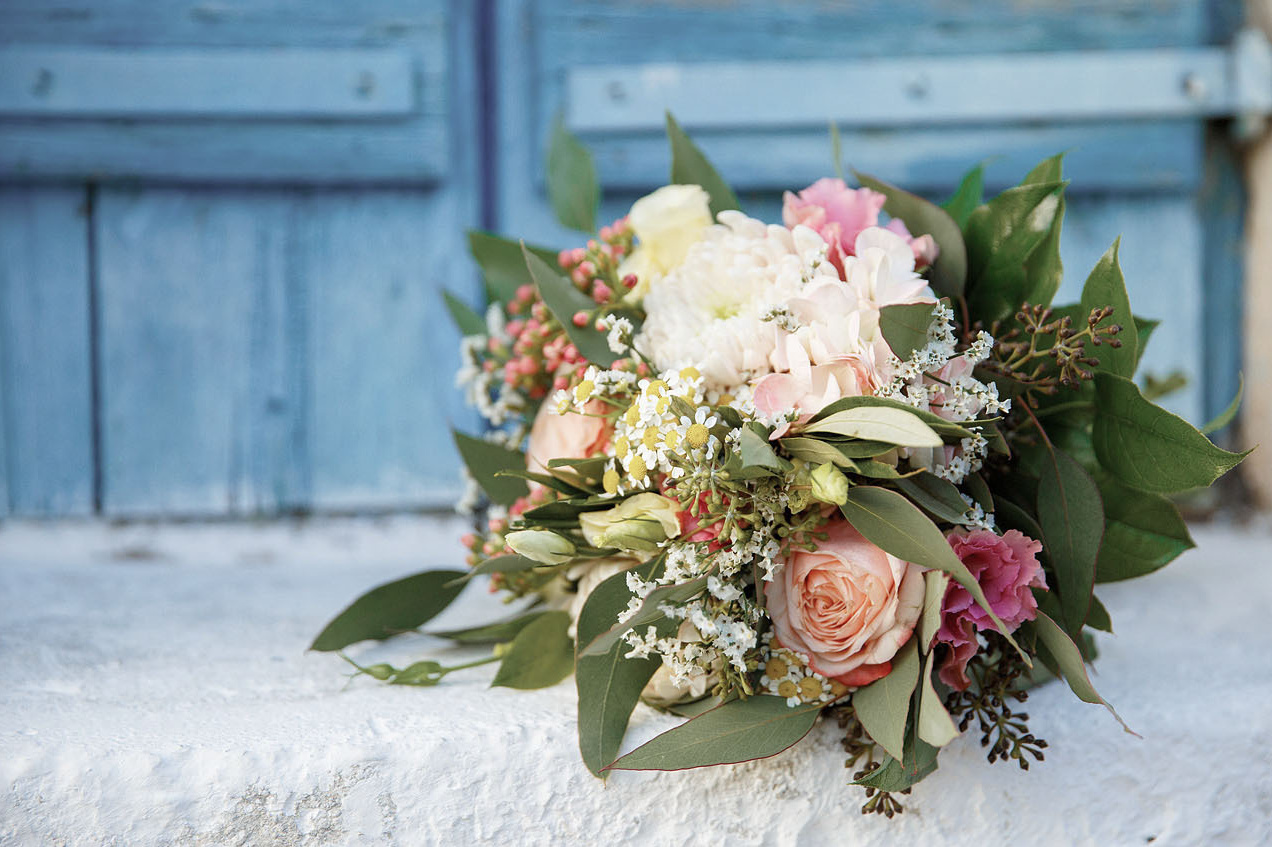 Букет невесты на фоне синих ставень окна на Крите. Фотограф, свадьба в Греции.