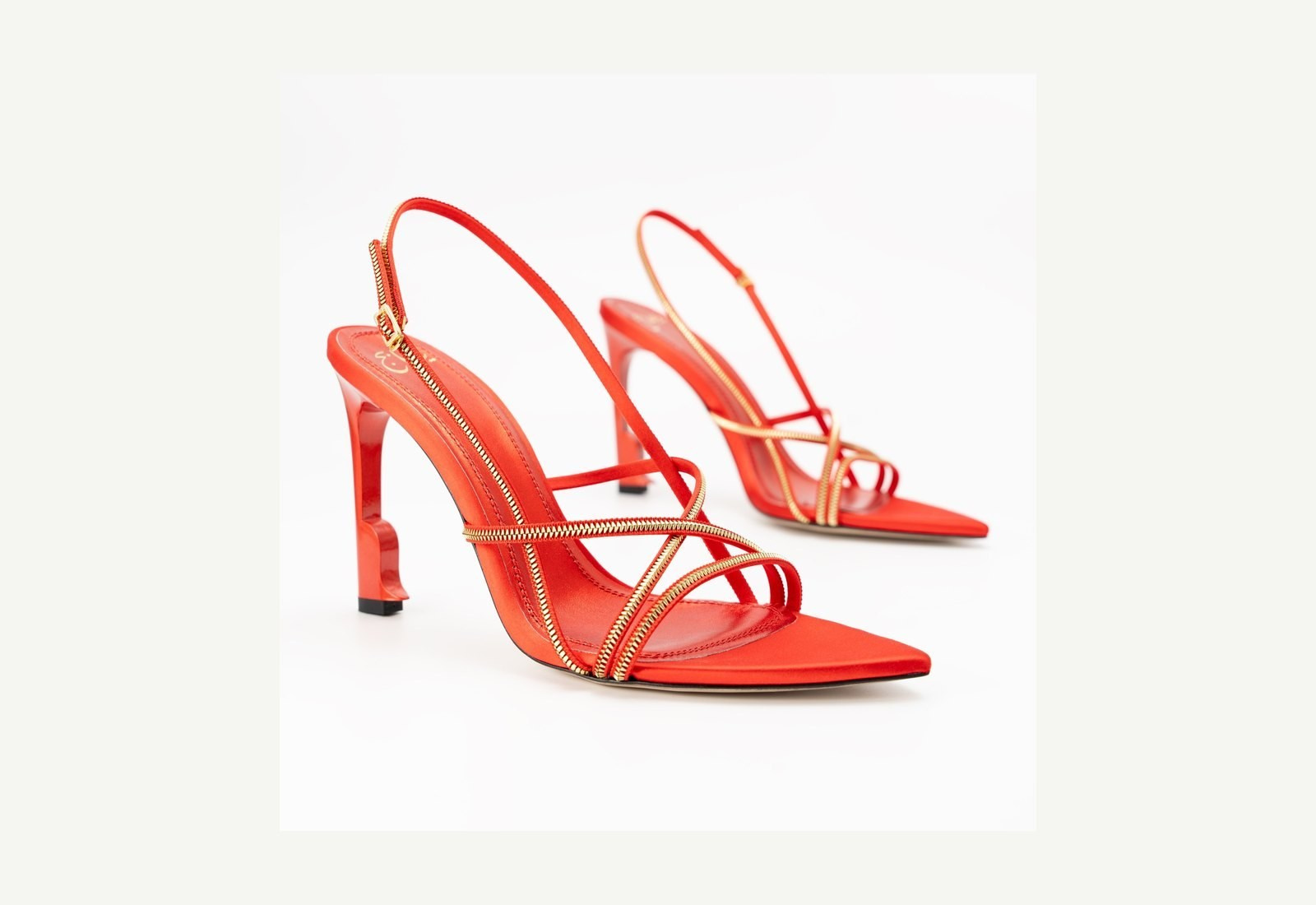 Red strappy high-heeled shoes photographed on a white background