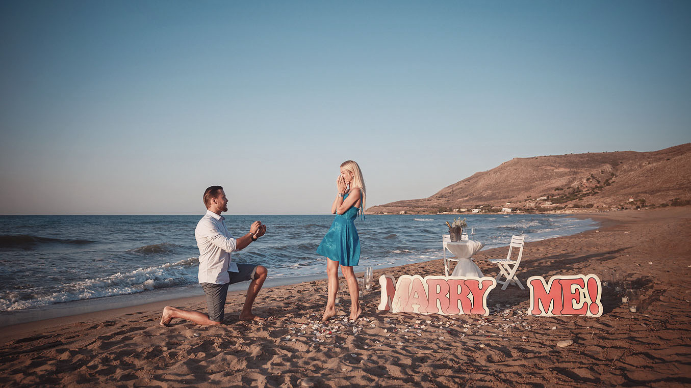 Предлагает кольцо девушке, делает предложение руки и сердца на Крите. Фотограф в Греции.