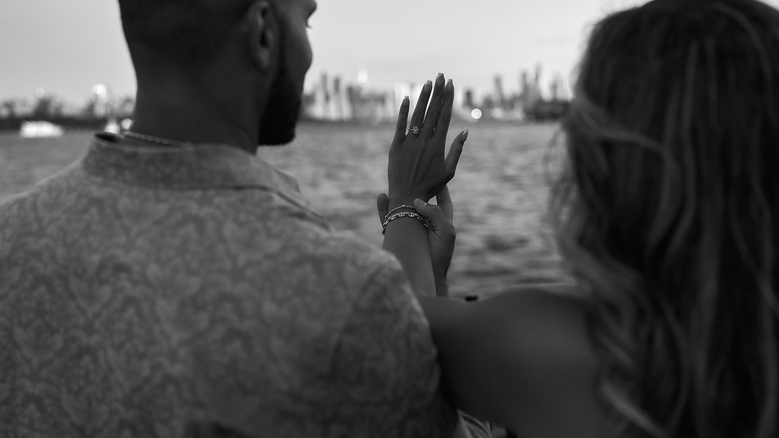 Romantic engagement photography of couple watching sunset by the water in New Jersey