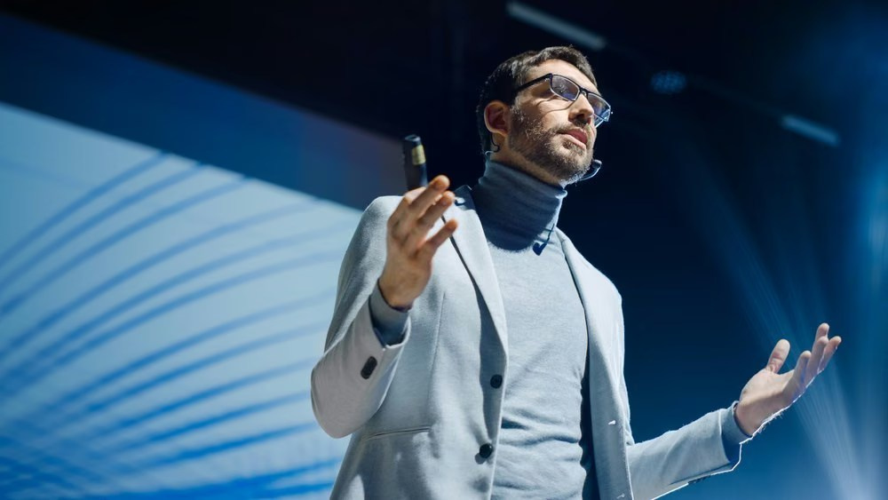 Keynote speaker presenting on stage during a professionally photographed business conference