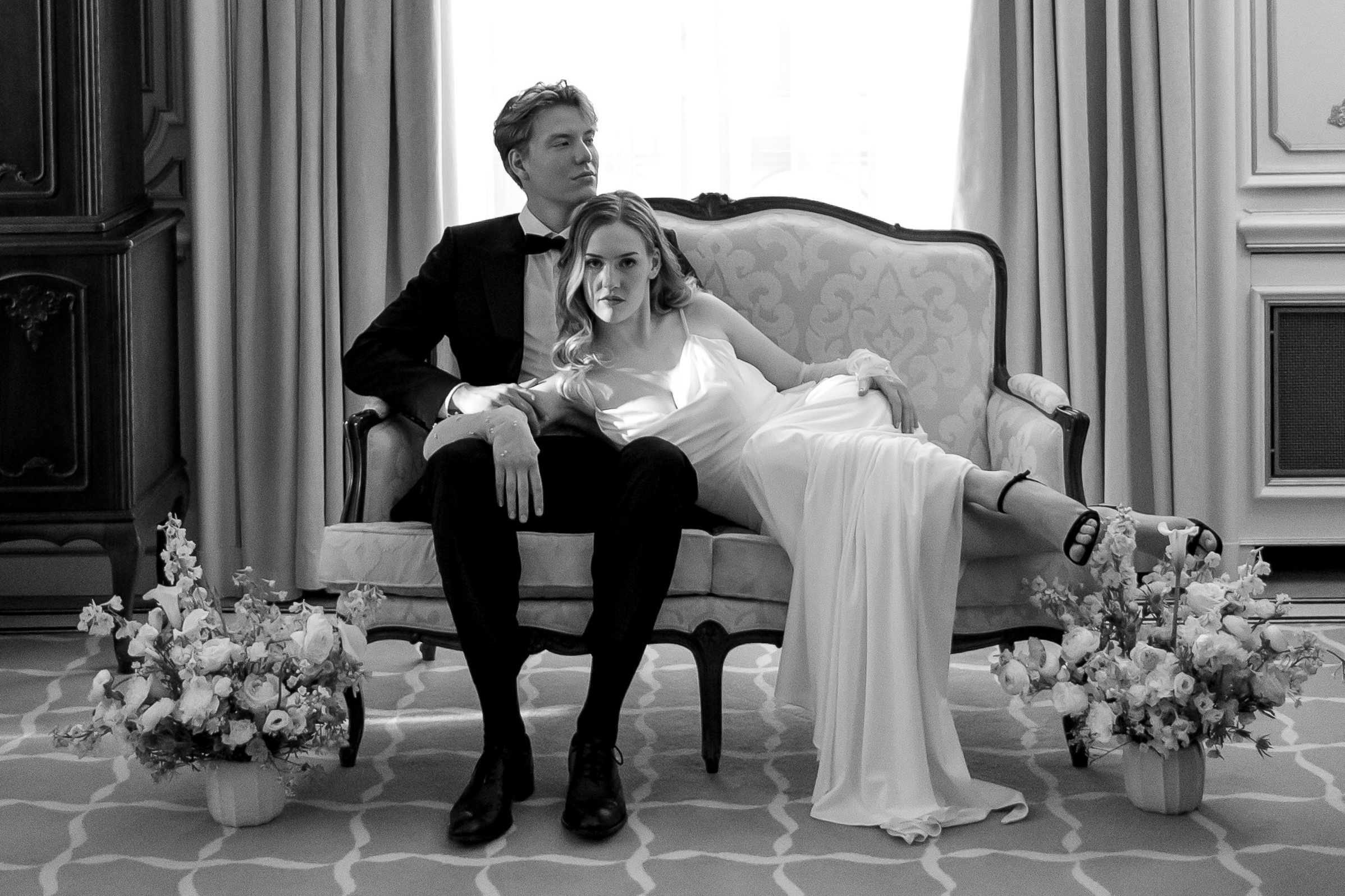 Brautpaar auf einem Sofa in elegantem Ambiente, zeitloses Schwarz-Weiß-Hochzeitsfoto in Berlin, Hotel Grand Westin Berlin