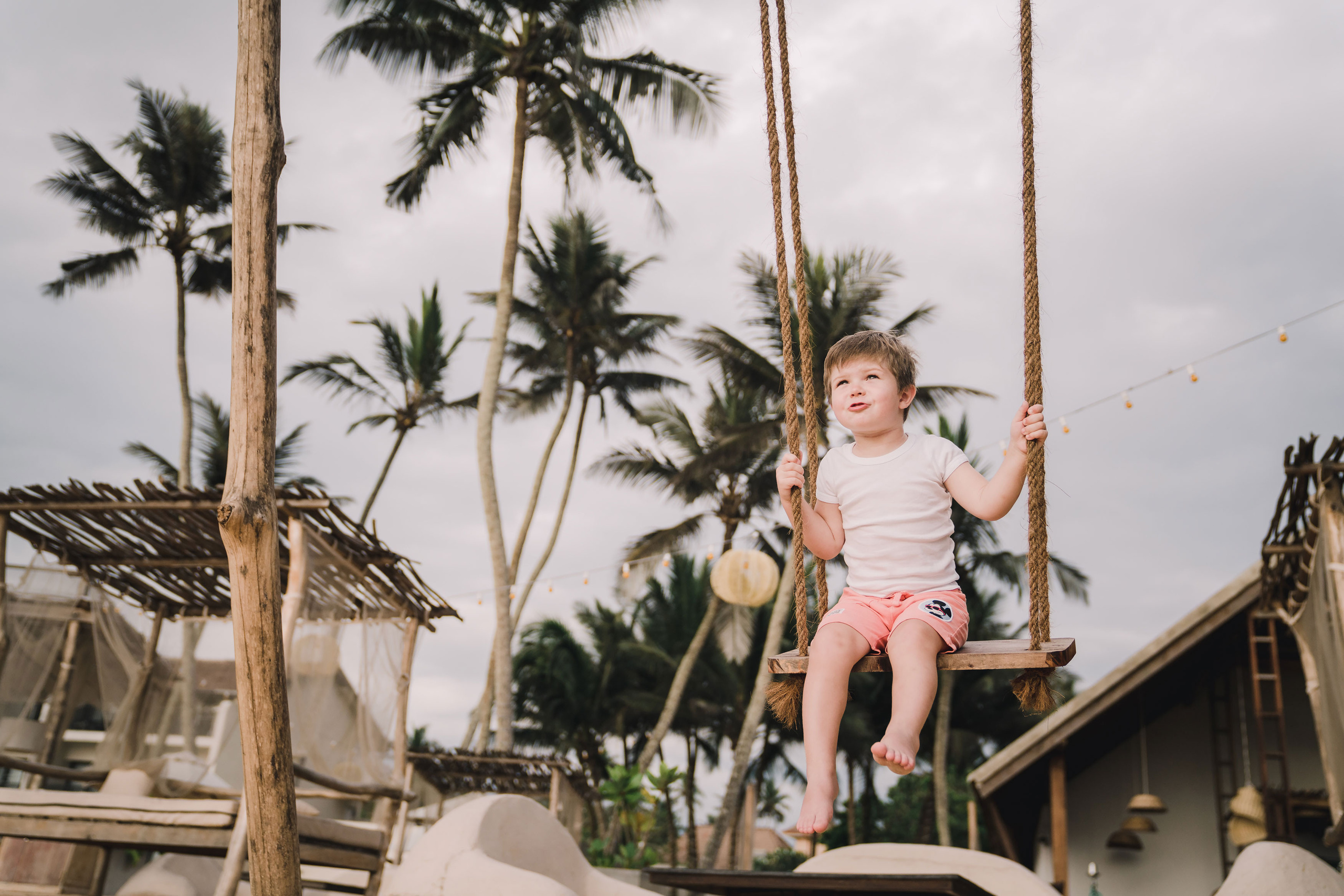 smiling boy enjoying riding a swing at Sri Lanka