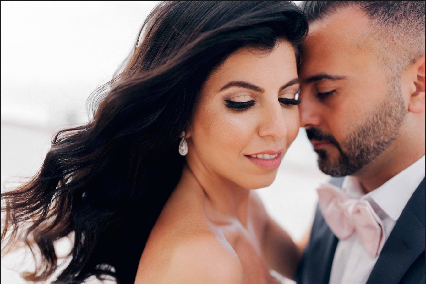 Портрет жениха и невесты, у невесты длинные черные волосы развиваются на ветру. 