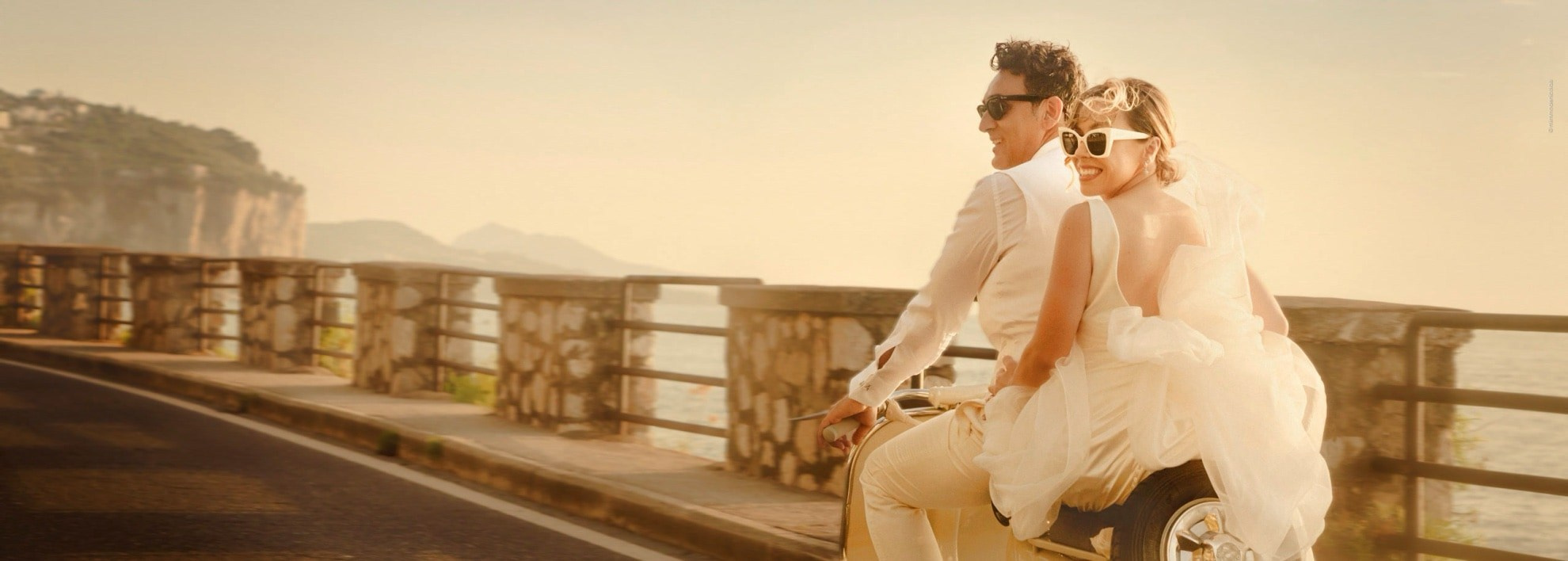 Destination wedding photographer in Italy capturing a bride and groom riding a vintage Vespa from Sorrento along the Amalfi Coast, a romantic and iconic Italy destination wedding photography filled with motion, elegance, and coastal beauty, photographed by Mimmo De Nicolais.