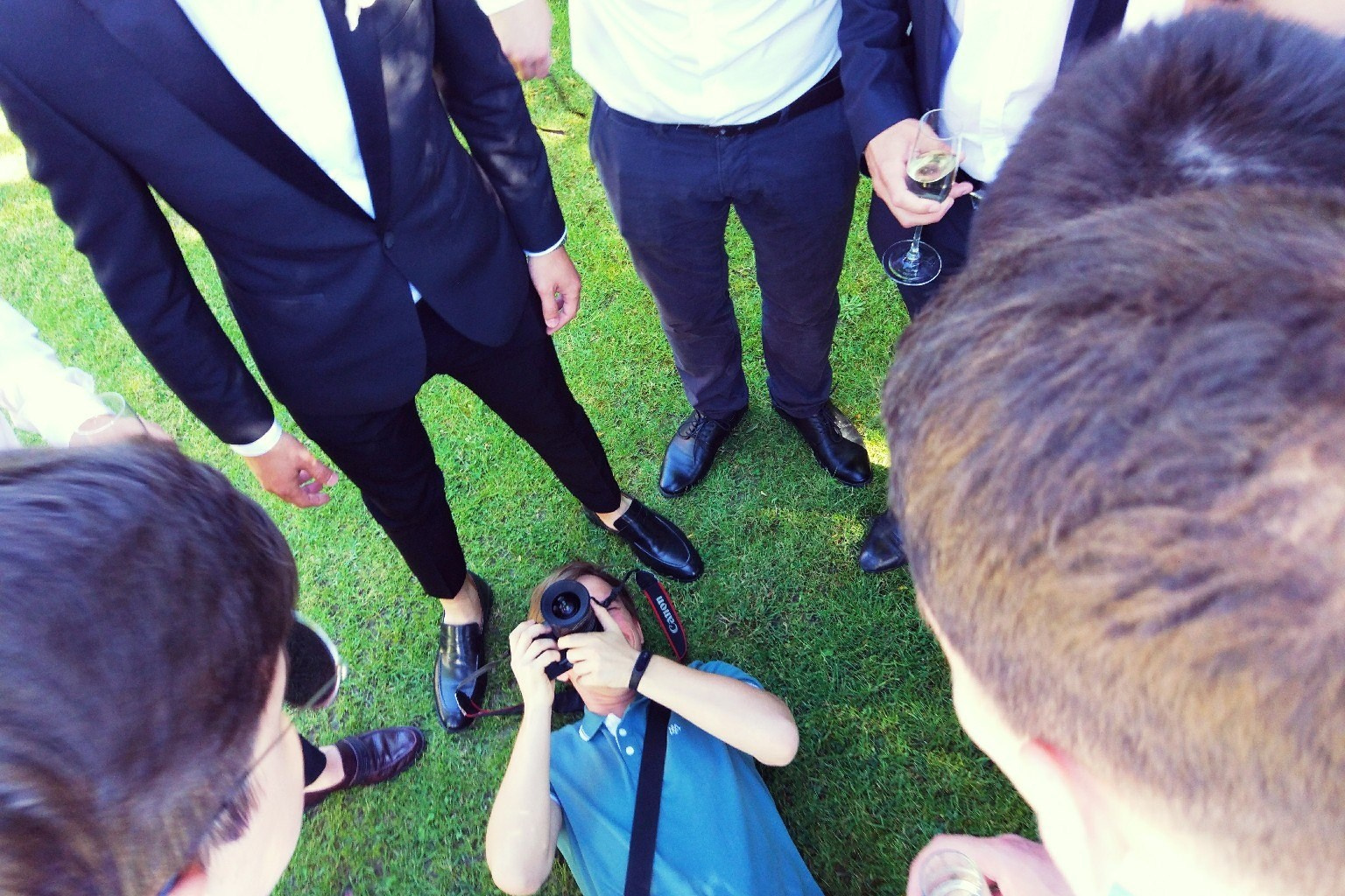 Group of people standing in a circle with feet touching in the center