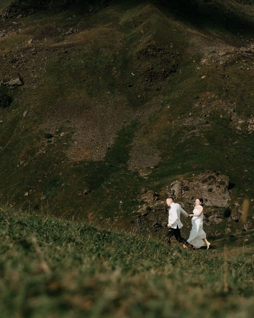 Couple running in mountains during sunset Kazbegi