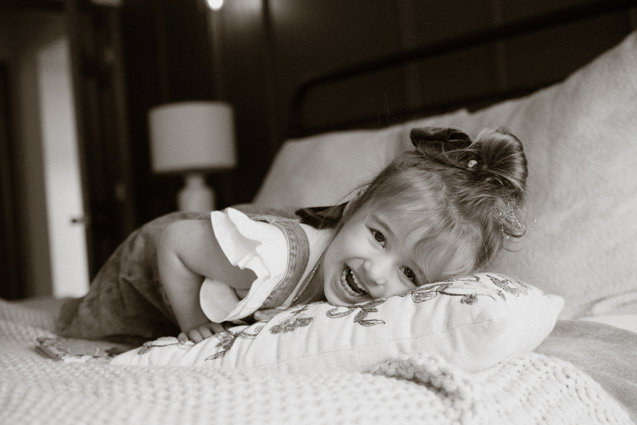 Happy kid playing on the bed during lifestyle family photography session in New Jersey