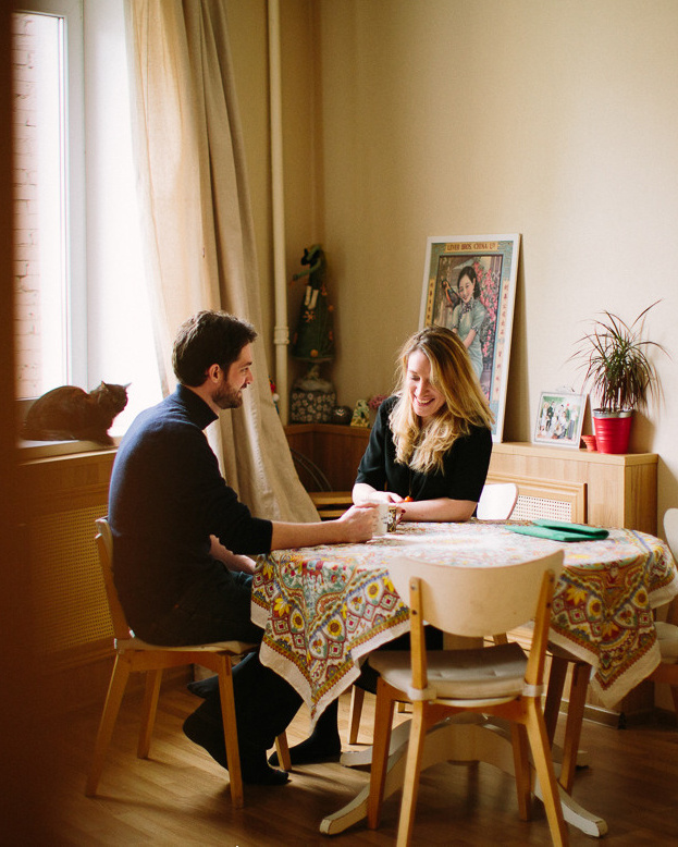 Couple is waiting for the baby sitting in their cosy living room and drinking tea 
