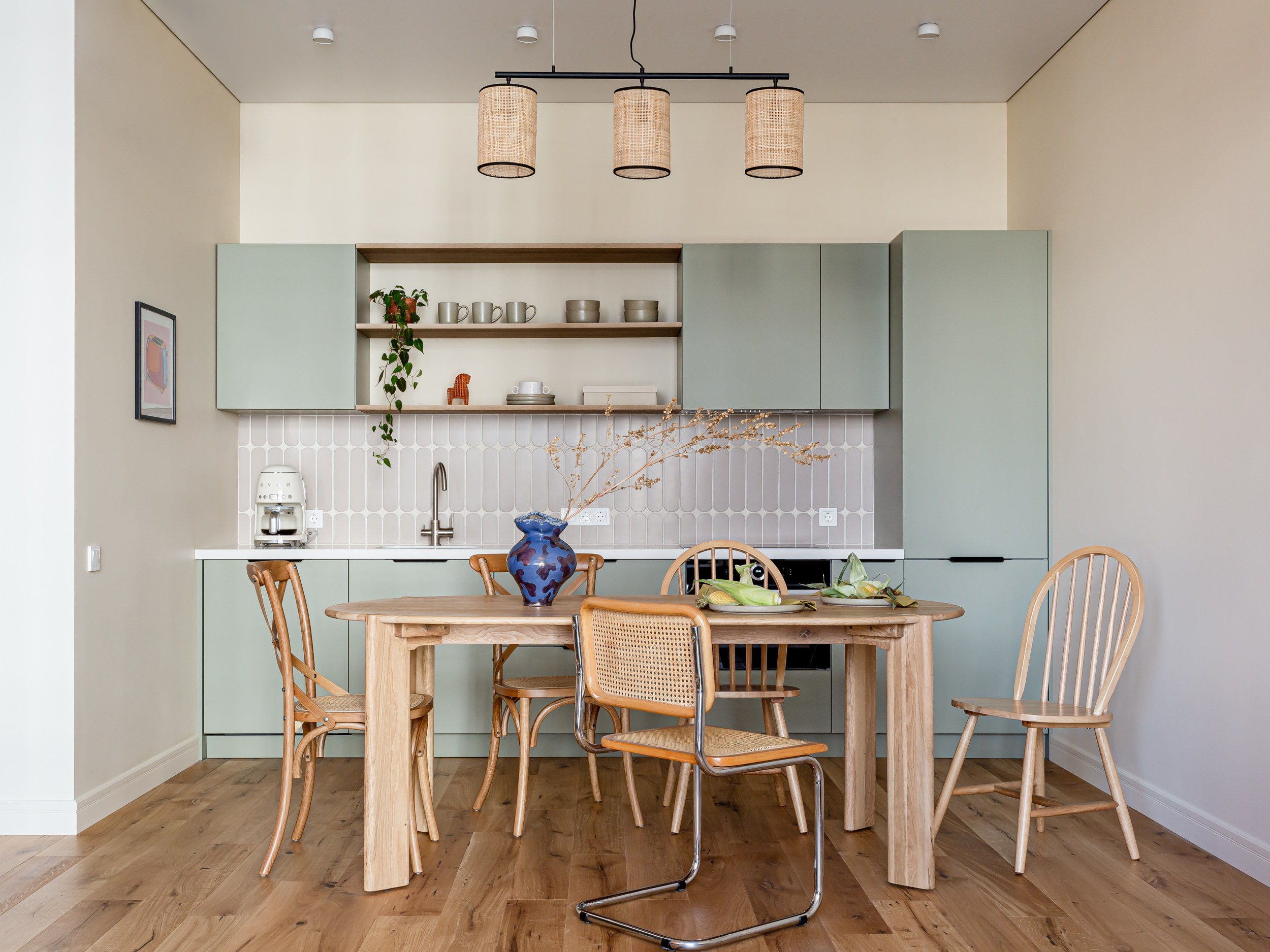 Интерьер зеленой кухни с овальной плиткой на фартуке и винтажной мебелью