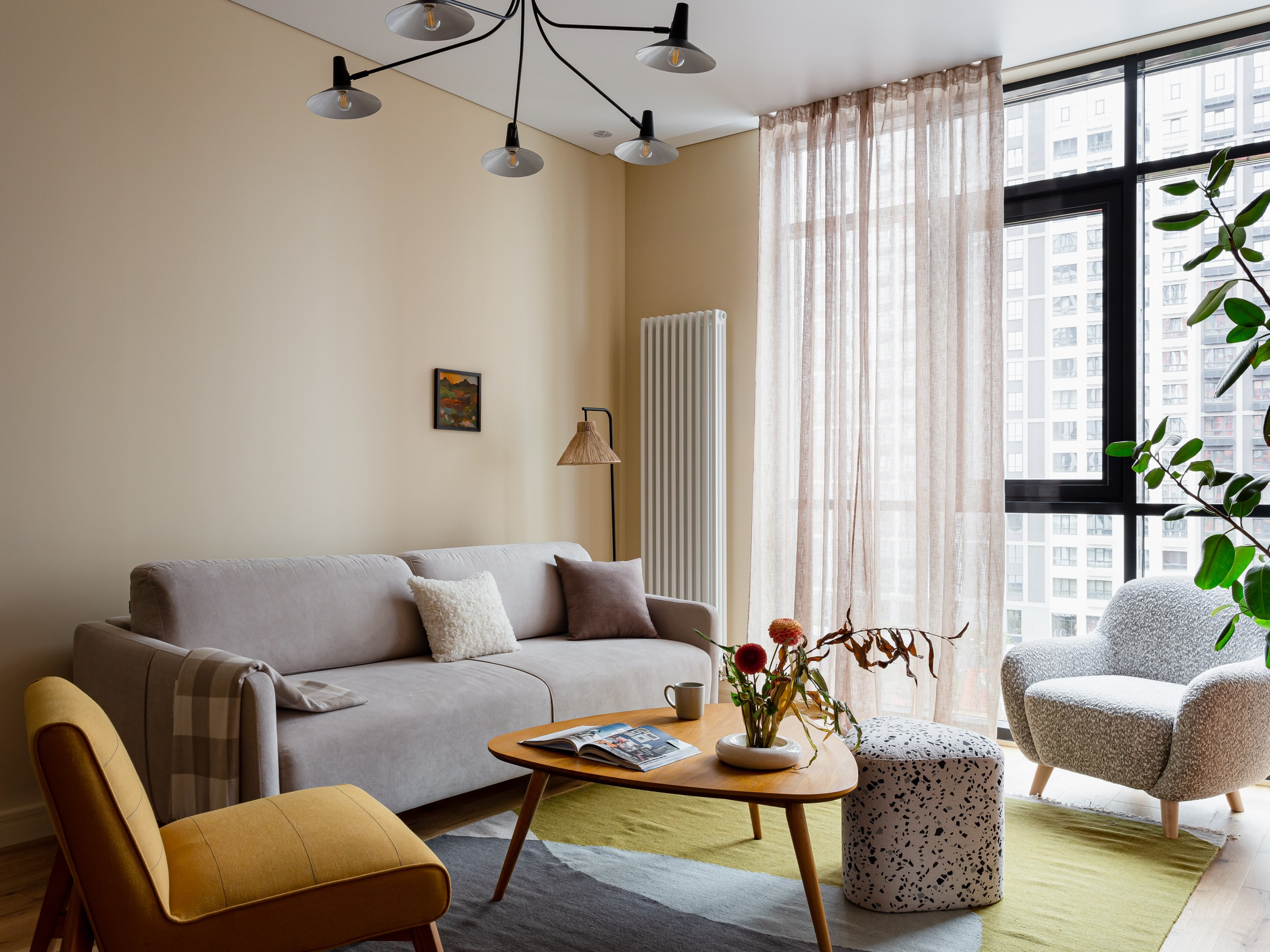 Уютная гостиная с огромным фикусом и креслом букле