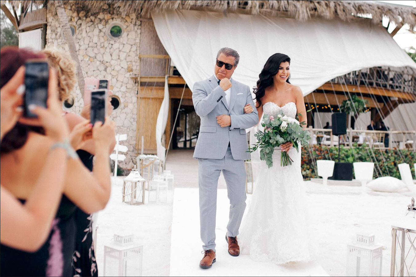 Отец ведет невесту к свадебной арке. 