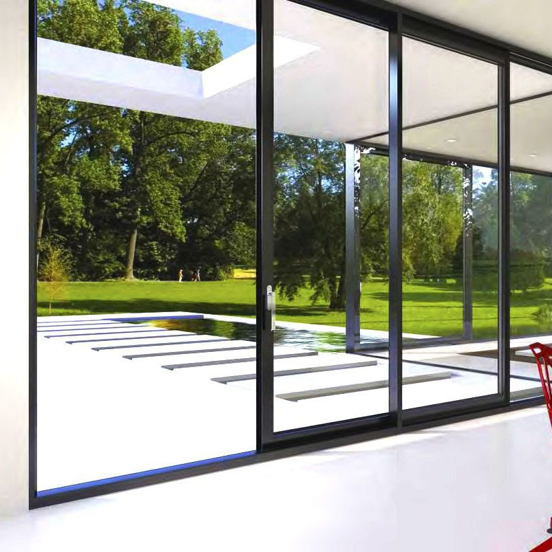 Комната частного дома с использованием подъемно-раздвижной системы открывает красивый вид на террасу и зеленый сад.