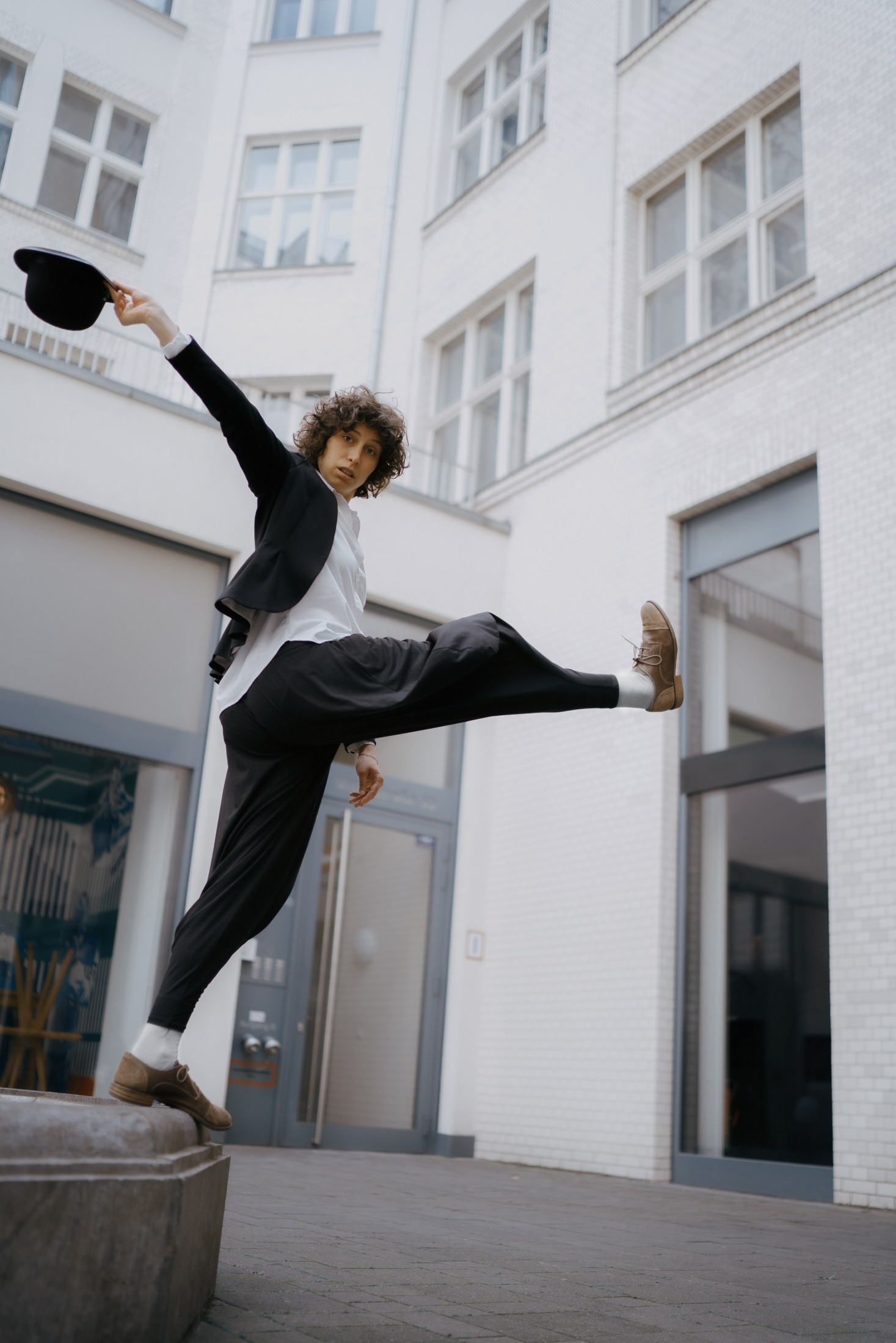 Dynamisches Portraitshooting Dresden – Mann springt mit Hut in der Stadt