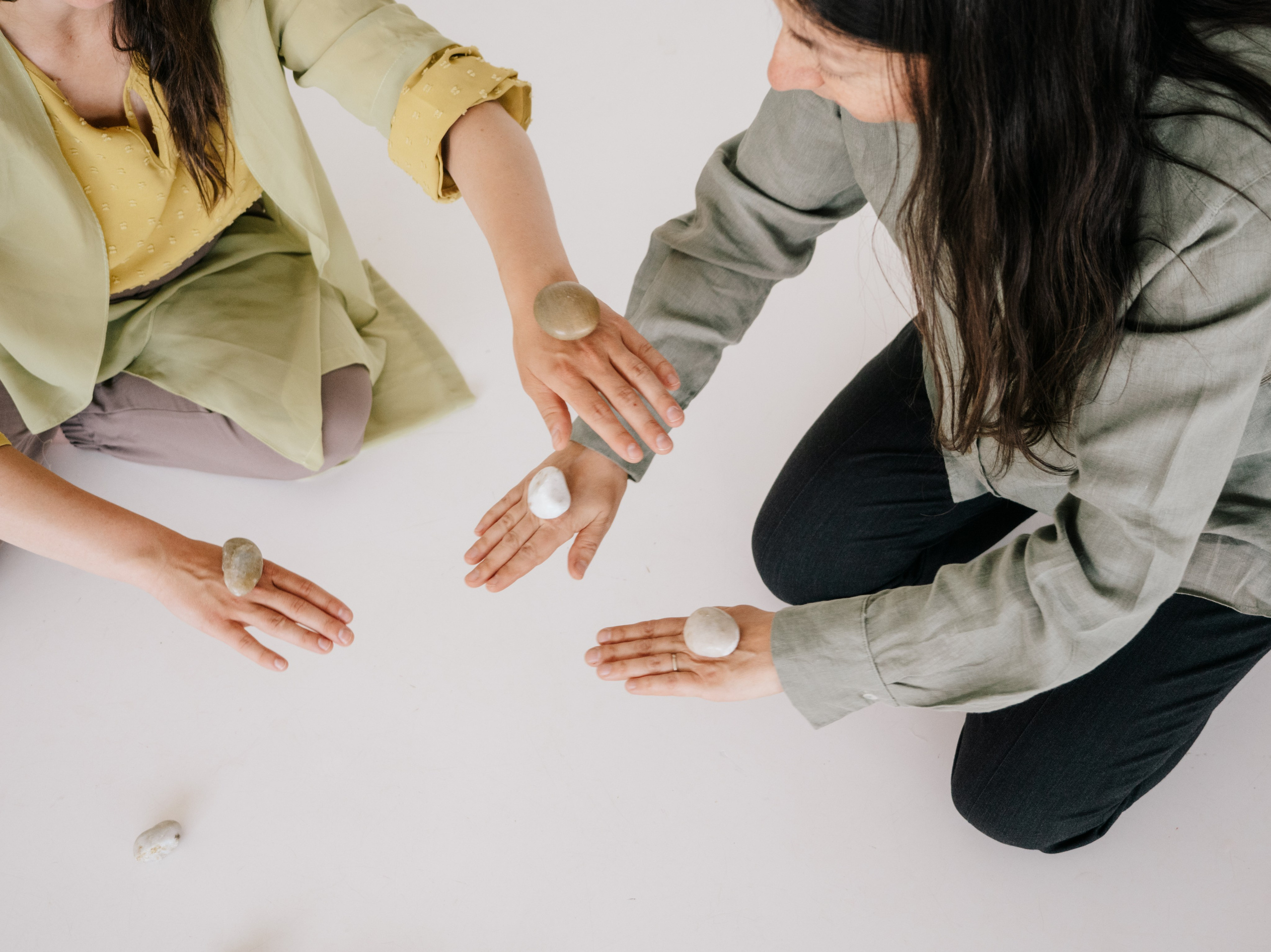 Des mains disposant de petits cailloux.