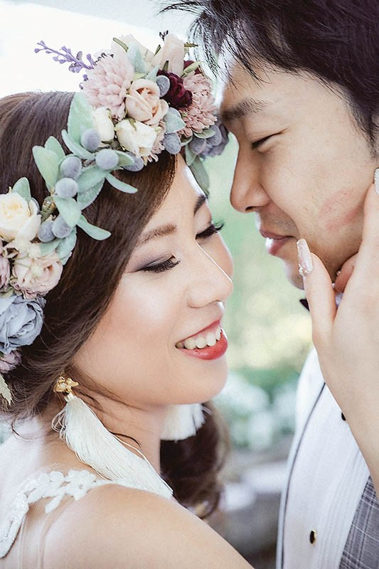 Cinematic pre-wedding photography — radiant Korean bride walks through a Prague street holding her gown as her groom carries her bouquet during their sunrise session, Prague — Kurt Vinion Photography