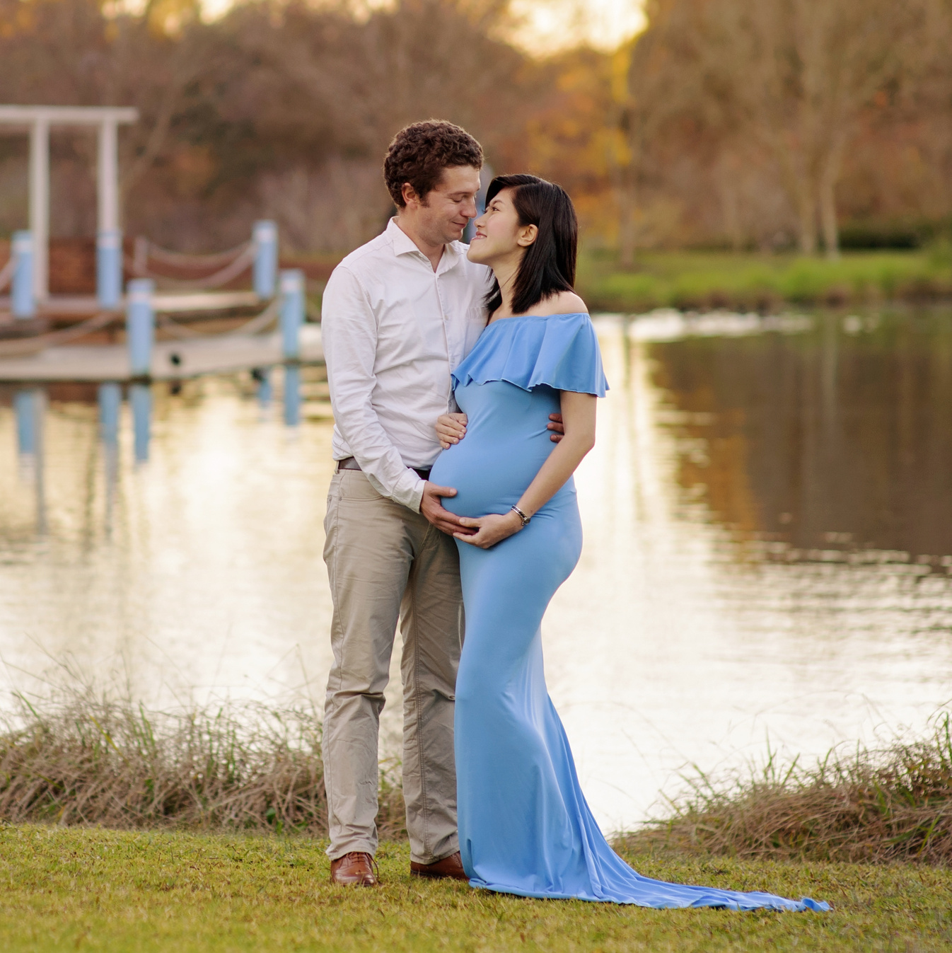 Outdoor maternity photo session in the park. A parents-to-be near the pond.