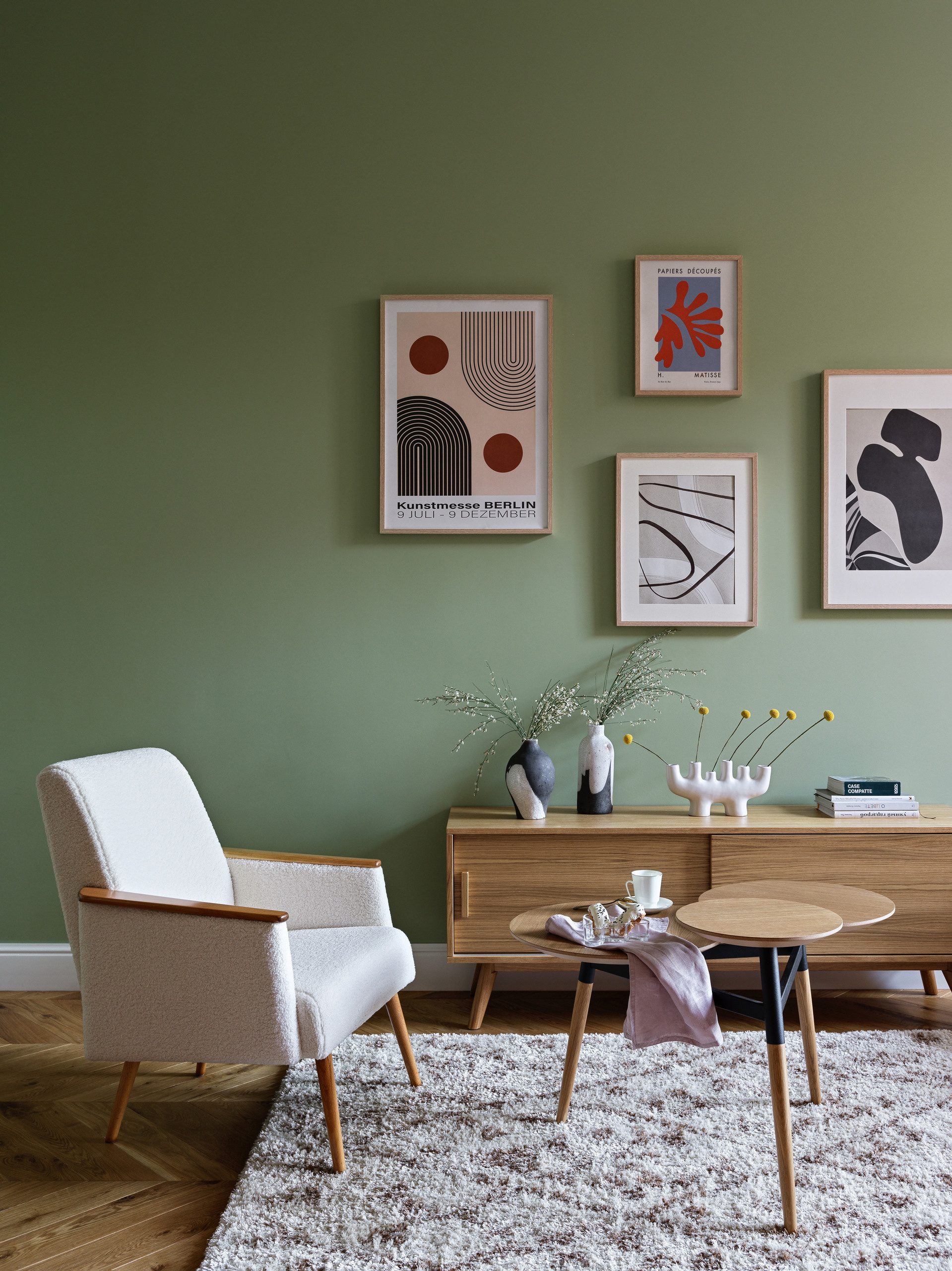 Уютная ретро гостиная с деревянными креслами, ковром с геометрическим узором и картинами в рамах.Спальня с винтажной кроватью и тумбочками