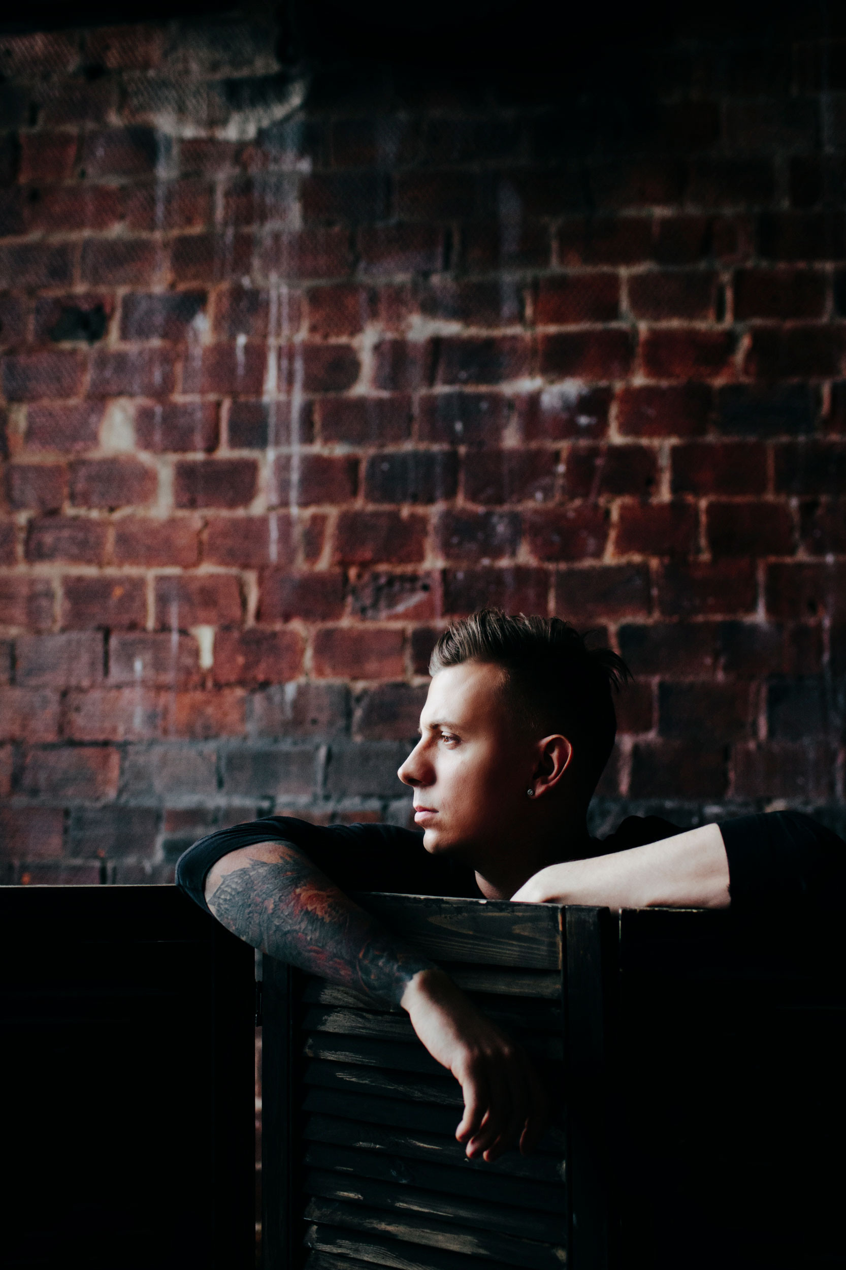 молодой человек на фоне красной кирпичной стены