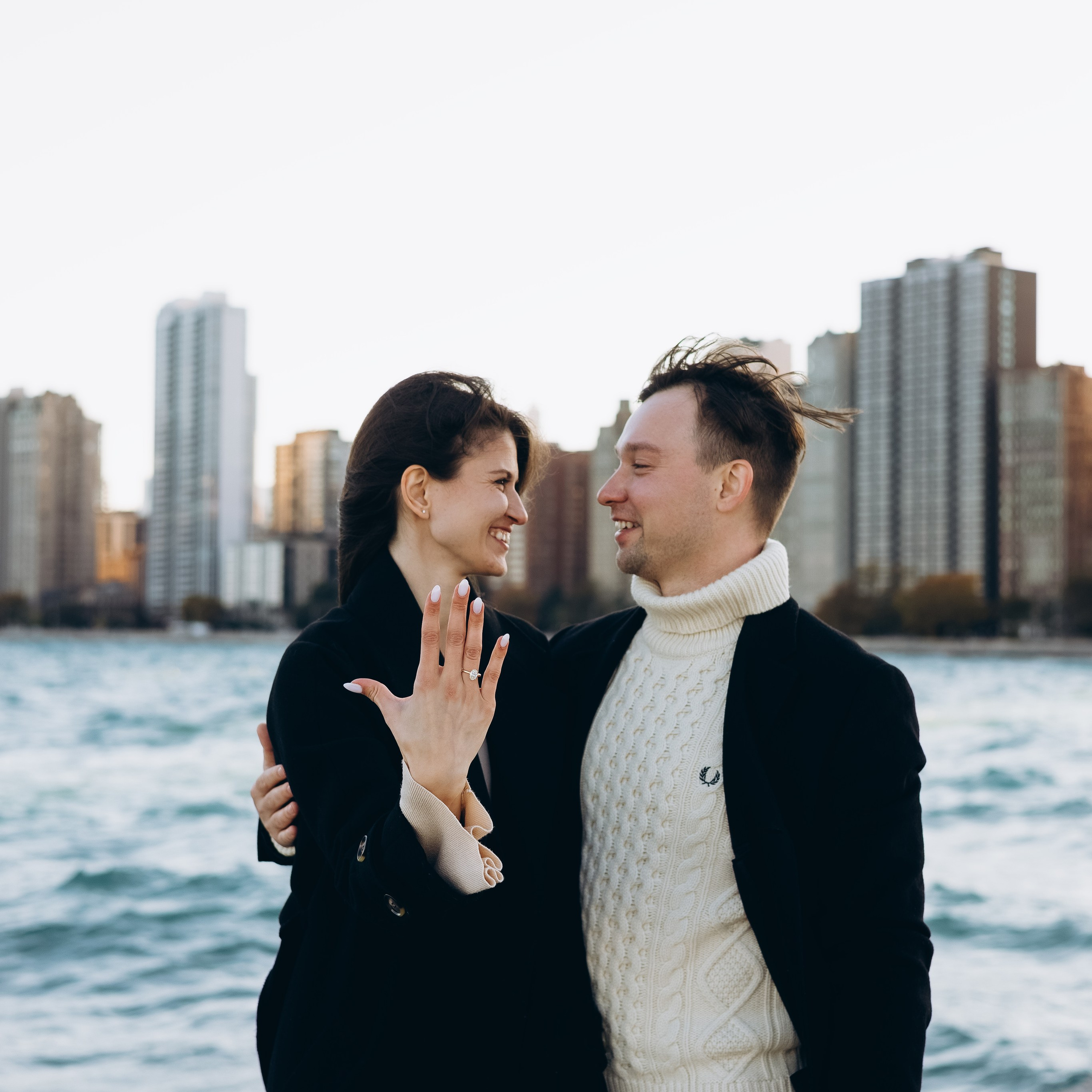 Couple walking along North Avenue Beach Pier during an engagement shoot in Chicago.