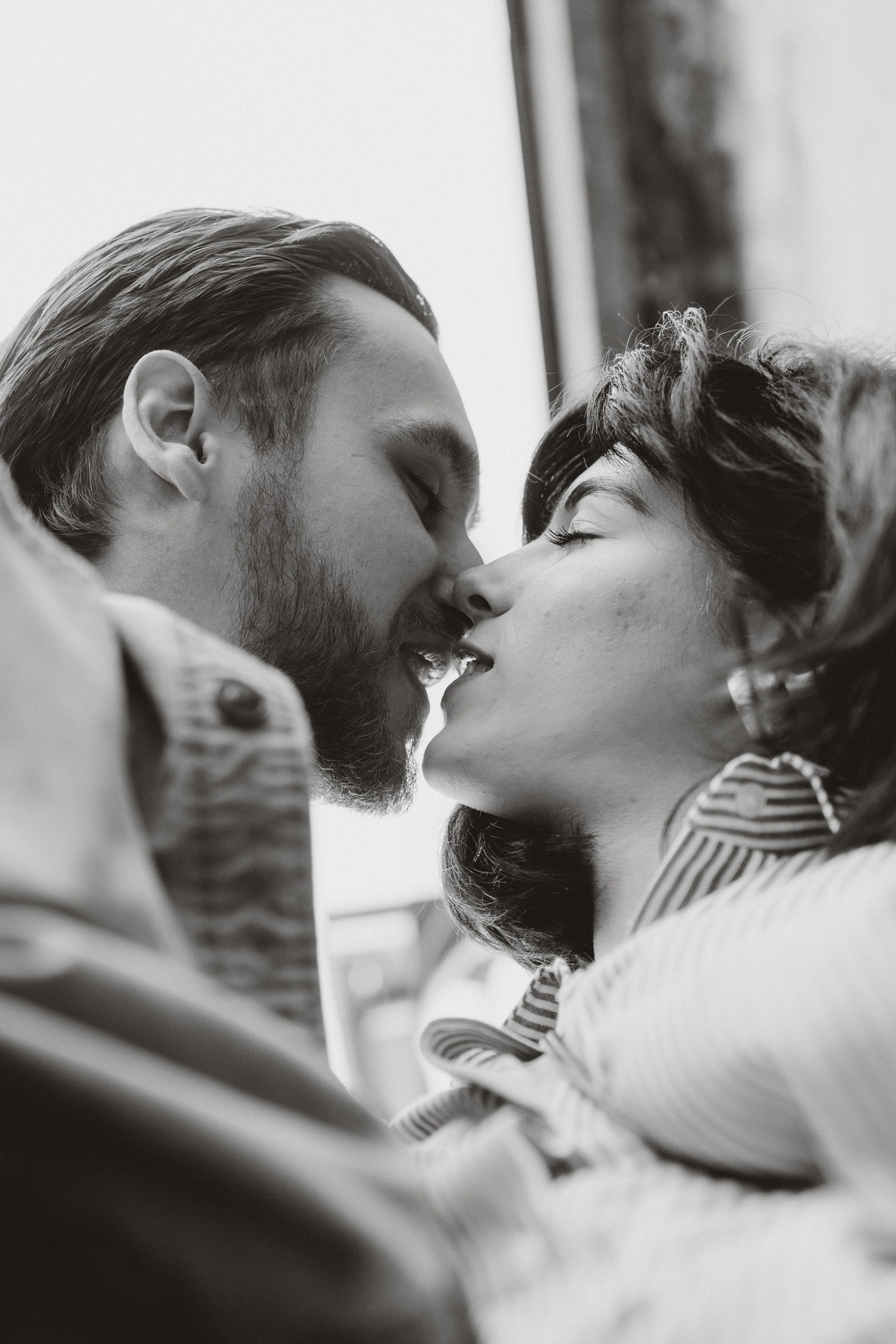 Black and white documentary portrait of a couple sharing a quiet moment outdoors