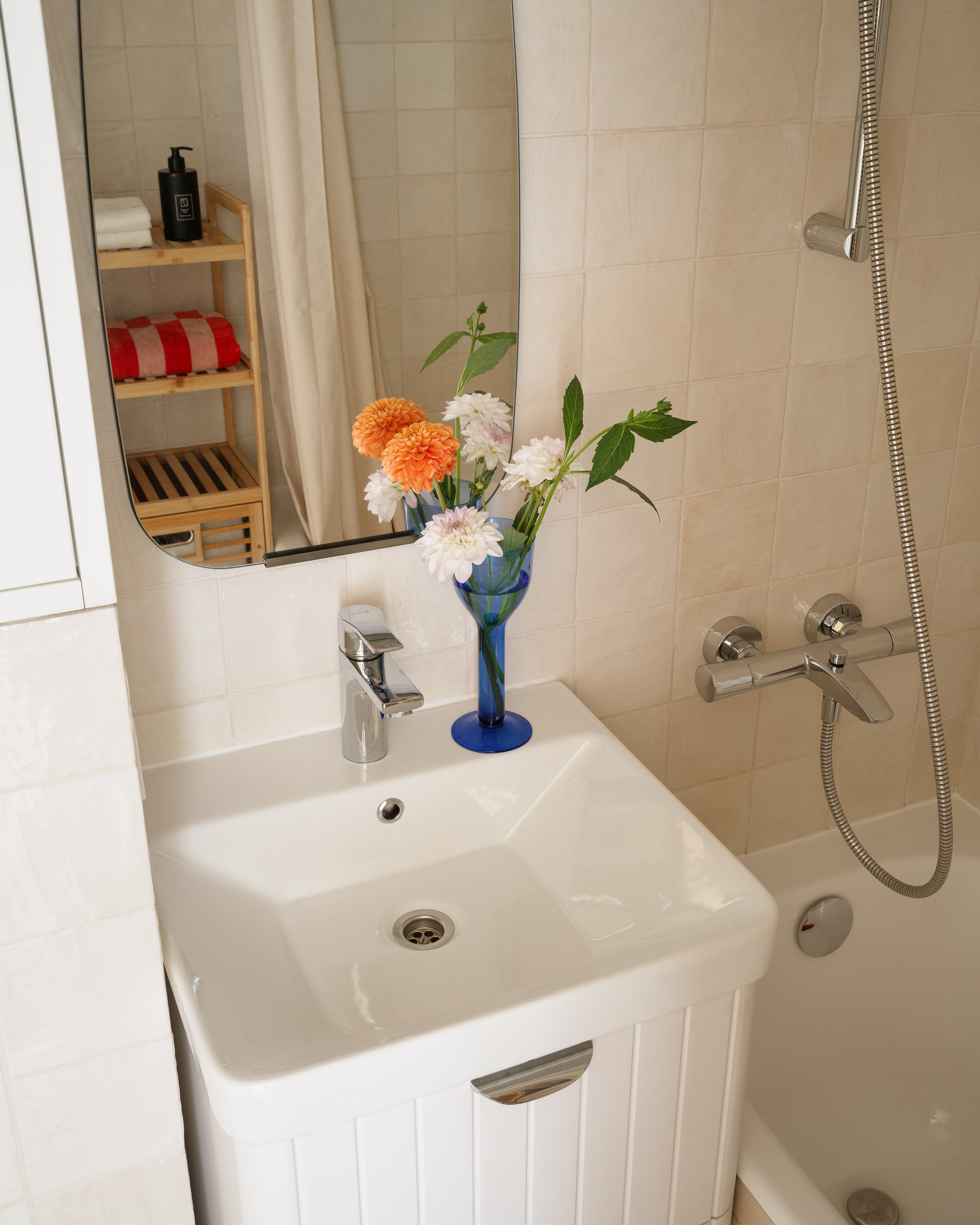 Смеситель в ретро-стиле над раковиной в ванной комнате с квадратной плиткой.