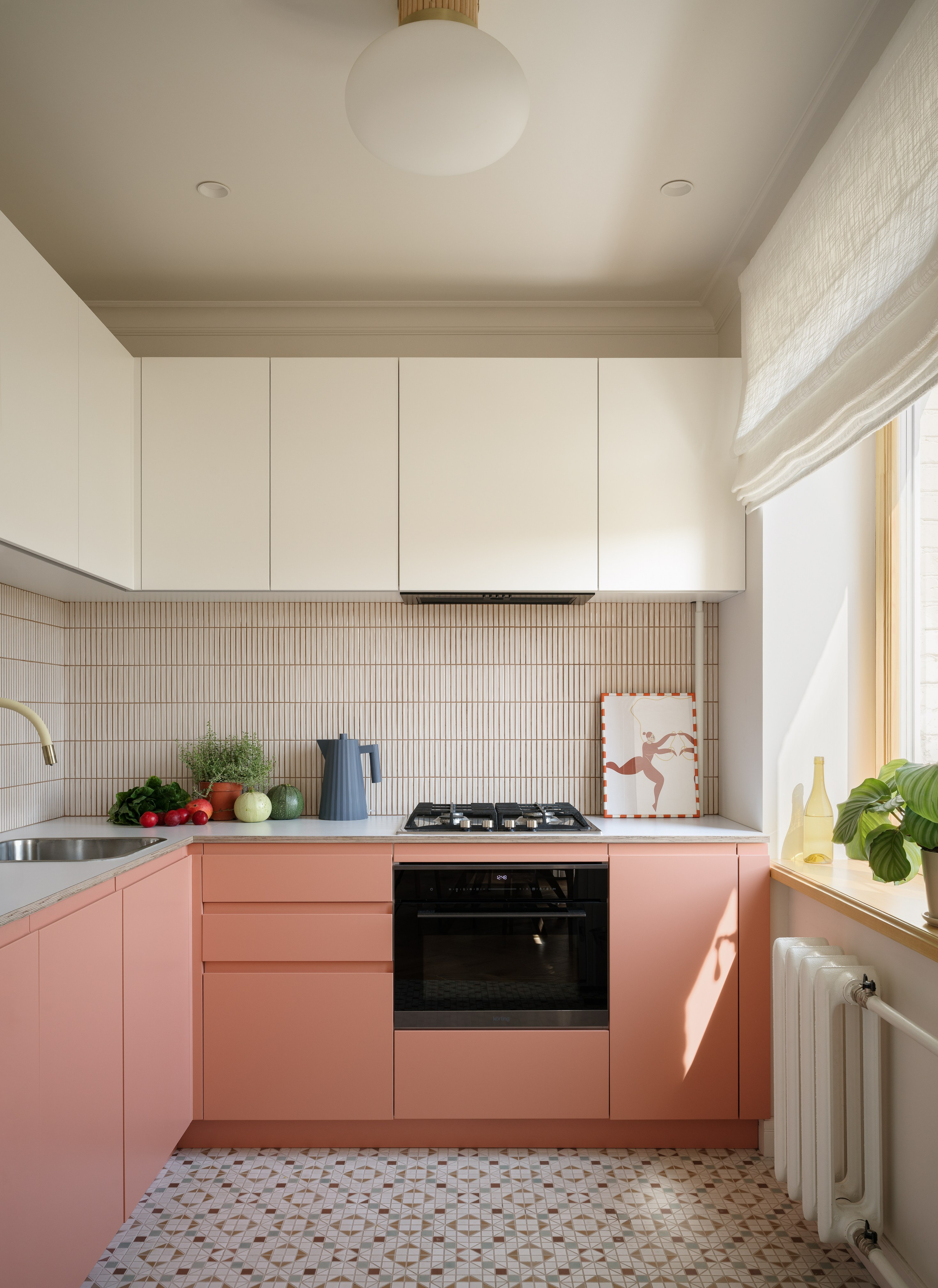 Интерьер кухни в стиле 70-х с яркими эмалированными фасадами и мозаичным полом.