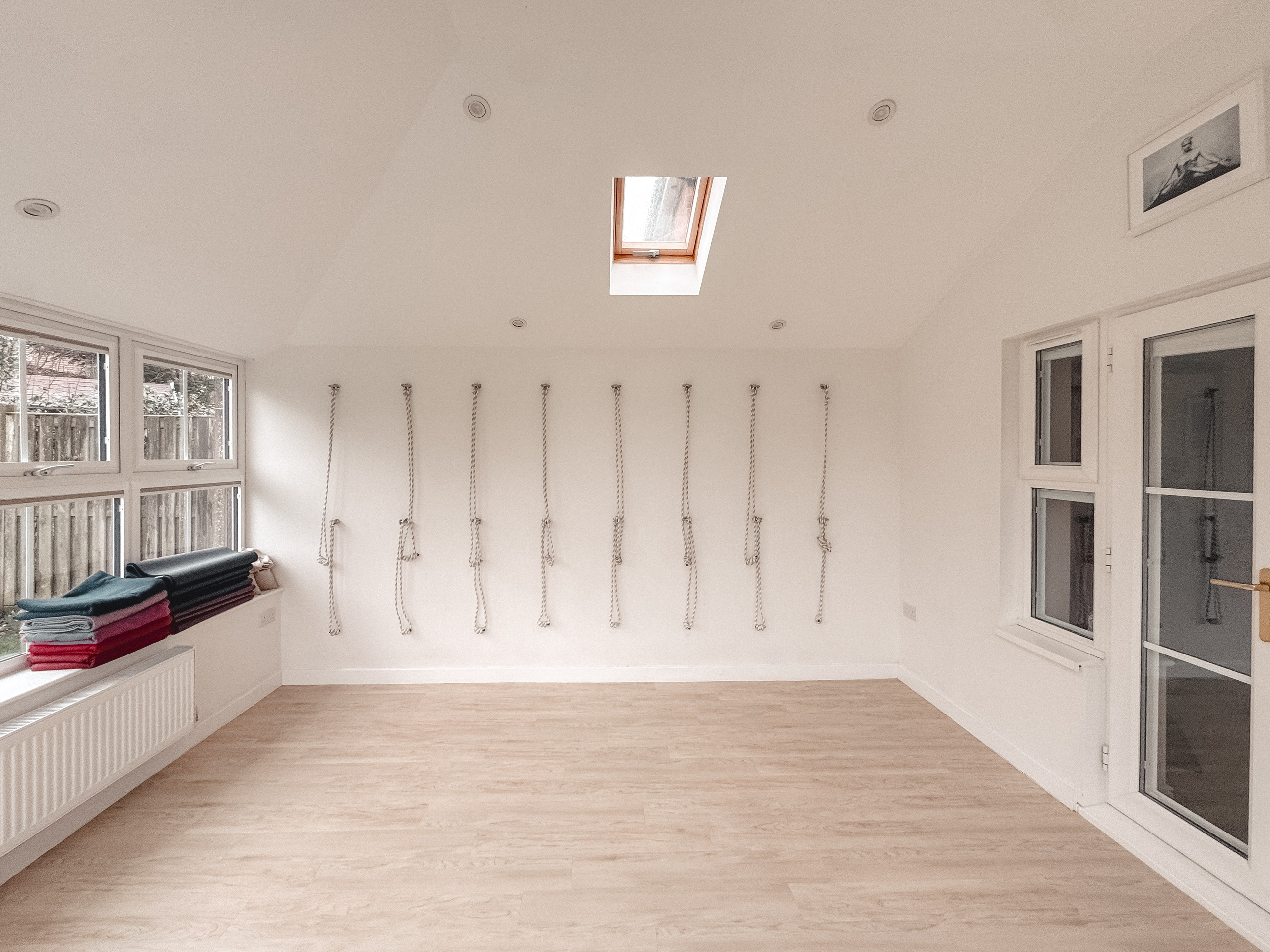 Calm Iyengar yoga studio in Solihull with wall ropes and wooden floor, set up for individual and small group sessions
