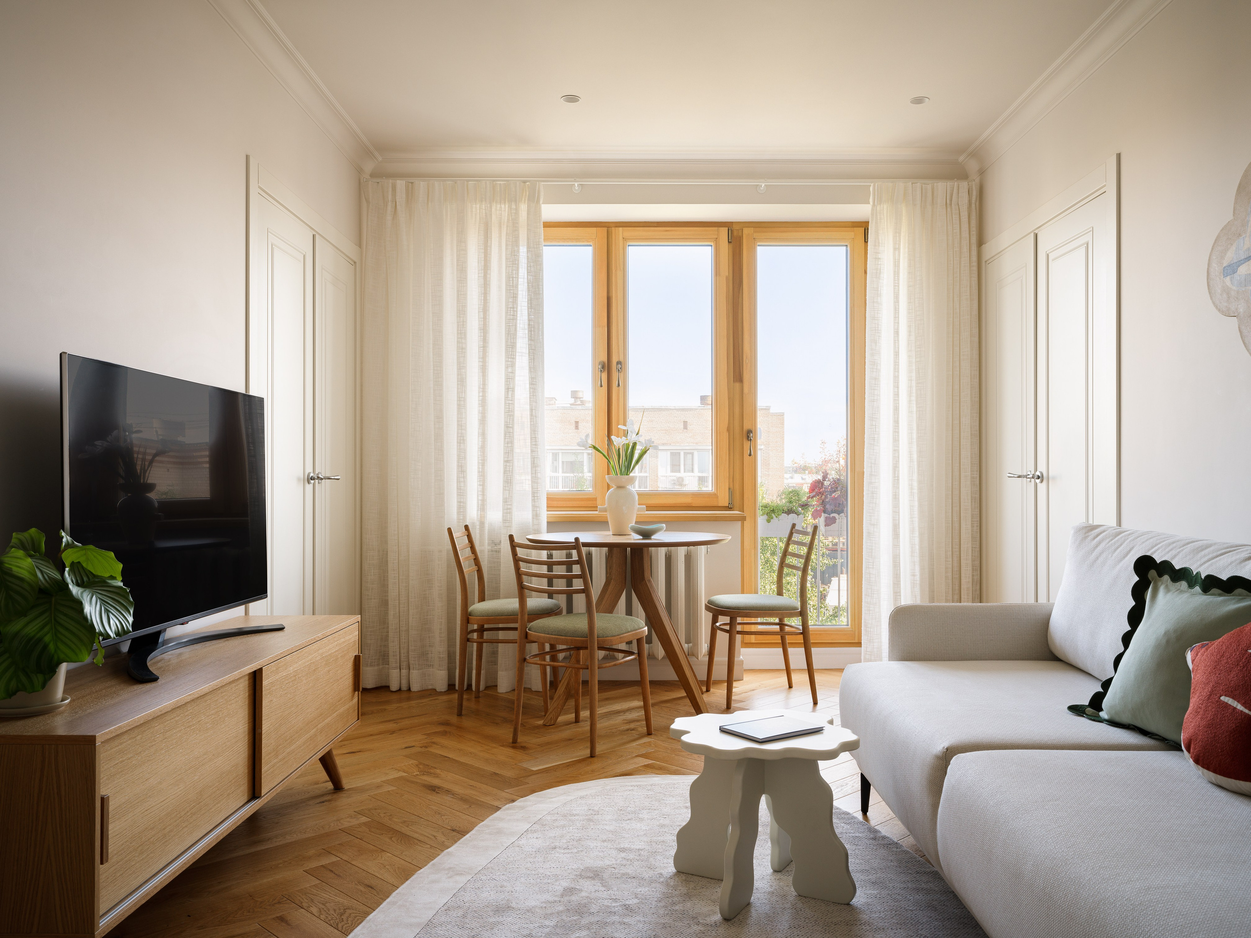 Гостиная в ретро-стиле с круглым обеденным столом и видом на балкон в проекте Анастасии Заркуа.