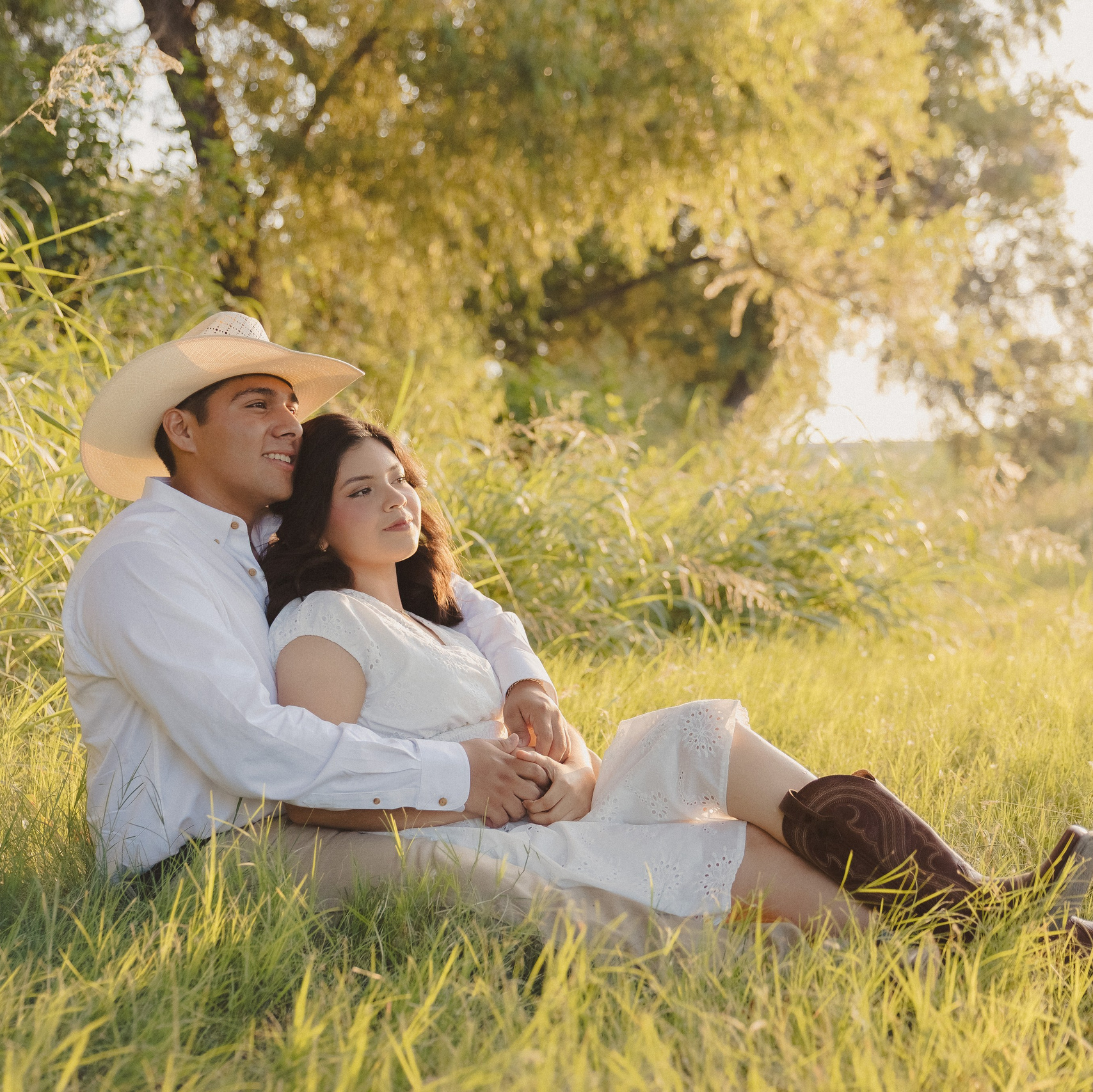 Sesión de fotos de pareja en exterior en un campo al atardecer.