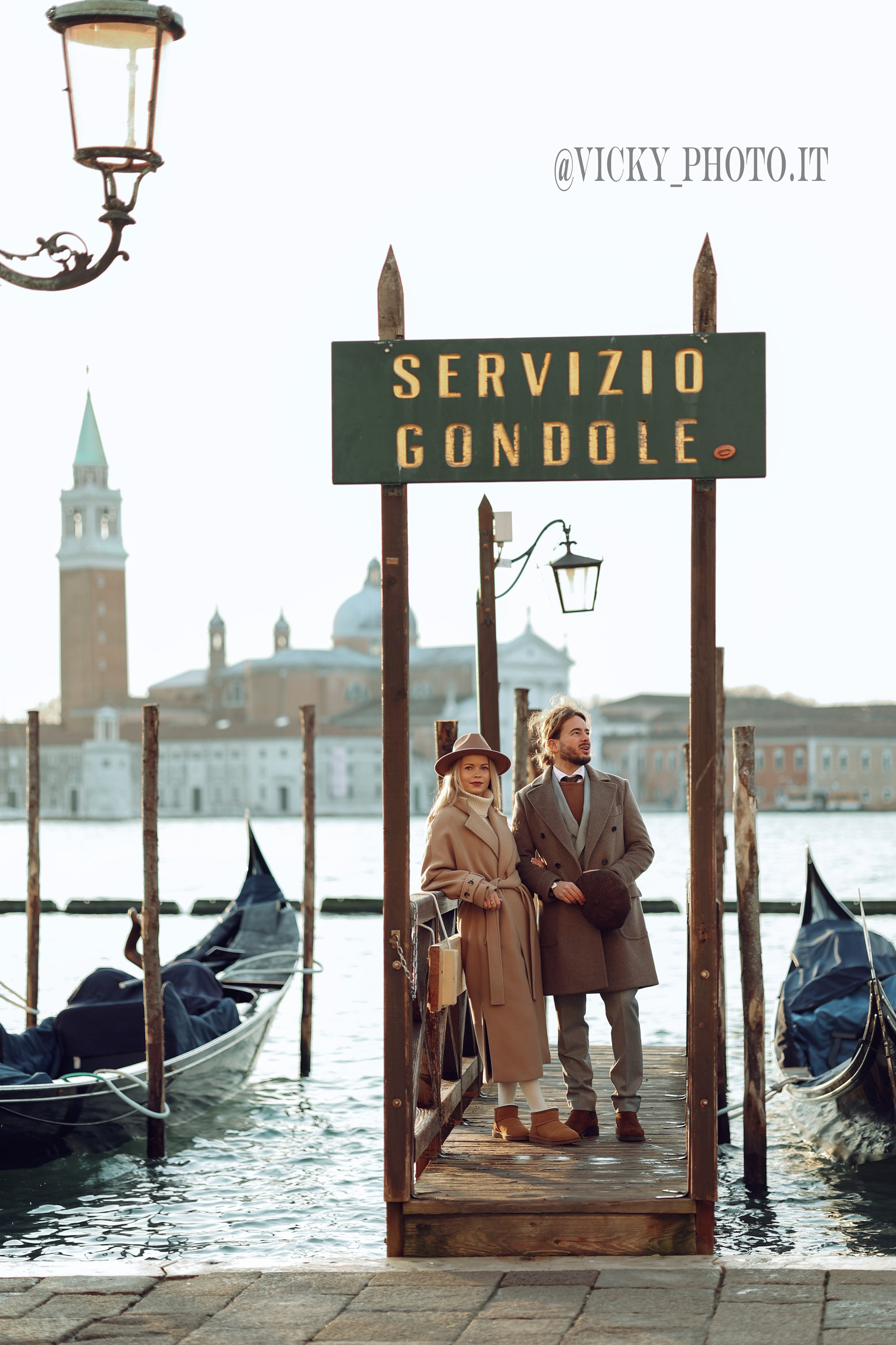 A couple against gondolas in Venice 