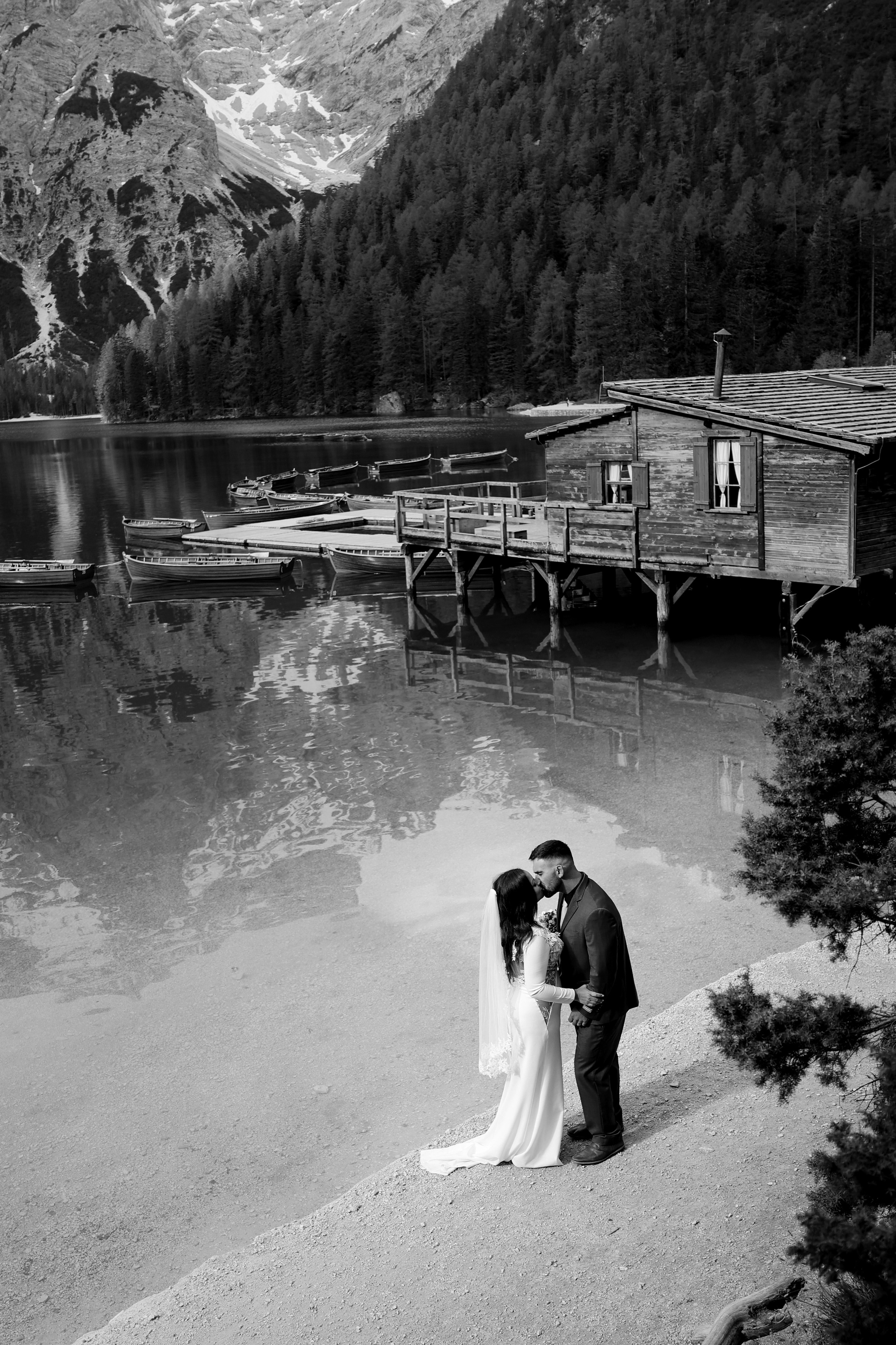 Bride and groom walking by Lake Braies during their Dolomites elopement