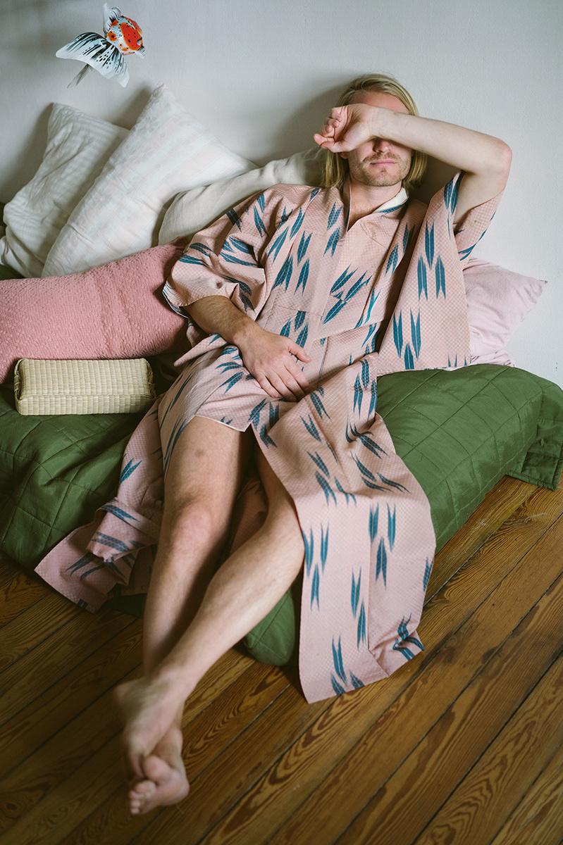 Mann im Bademantel auf dem Sofa liegend als Vorschau für Partnerbilder