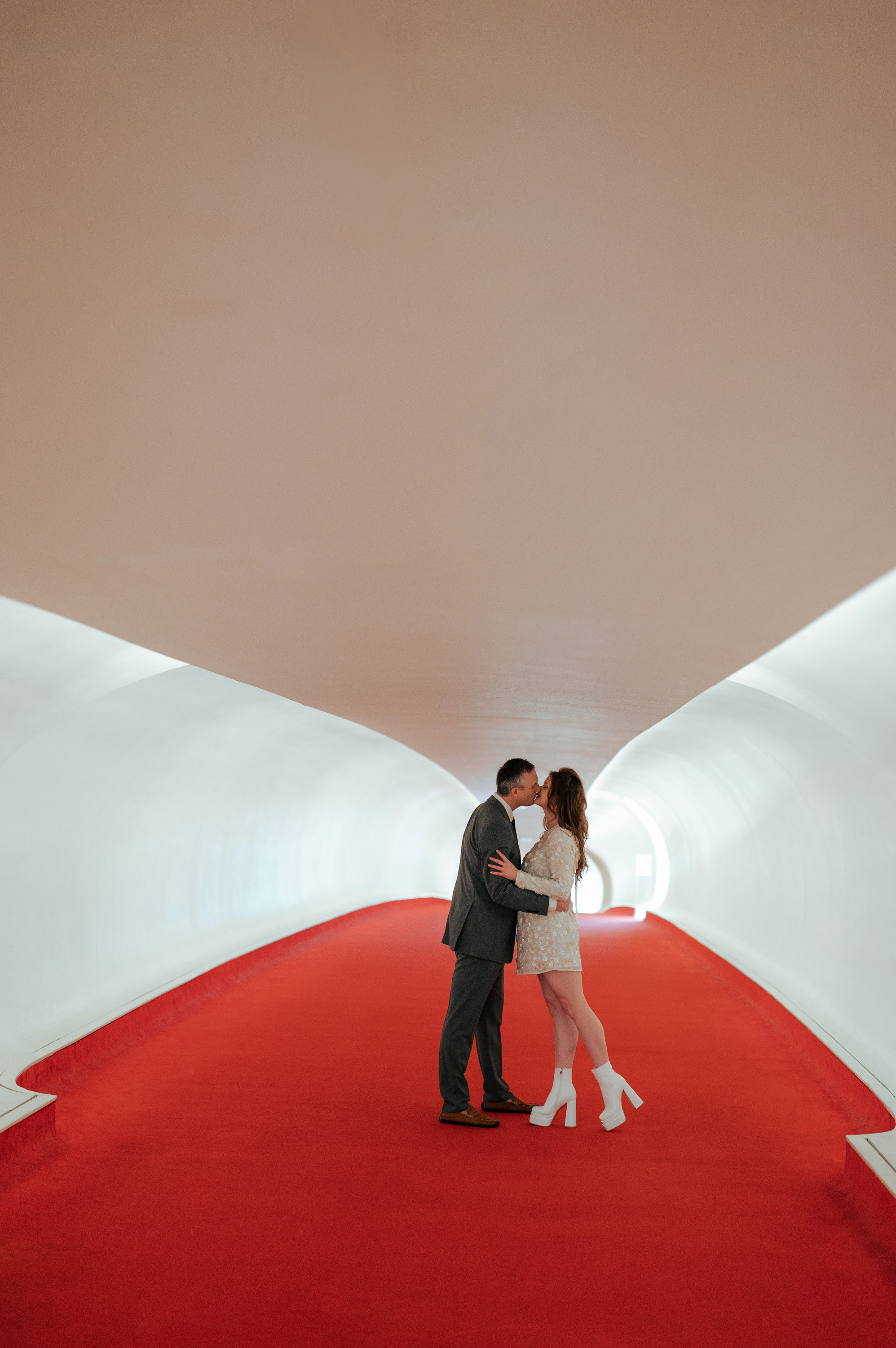 a couple kissing in a white tunnel