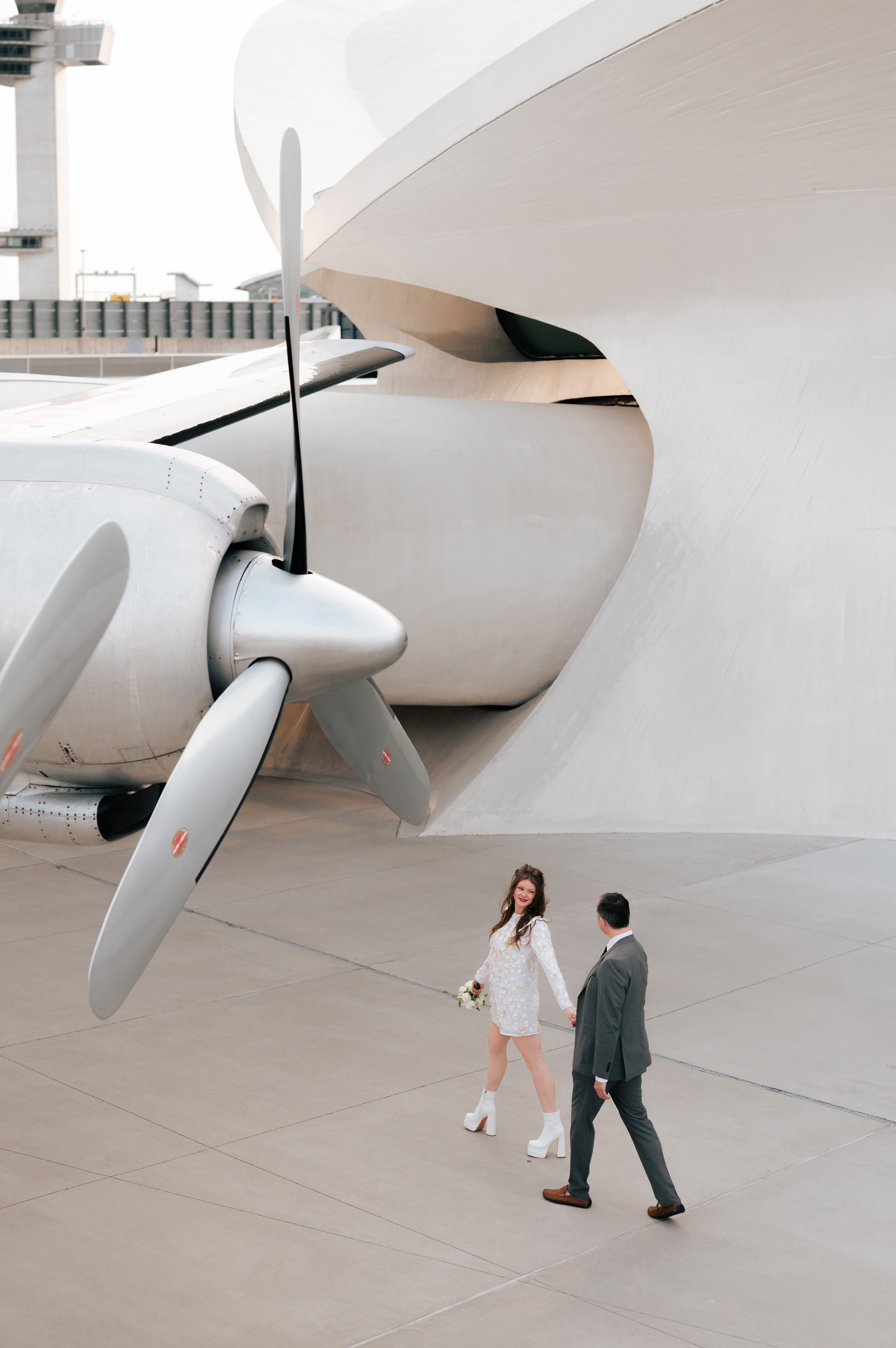 a couple walking in front of a plane