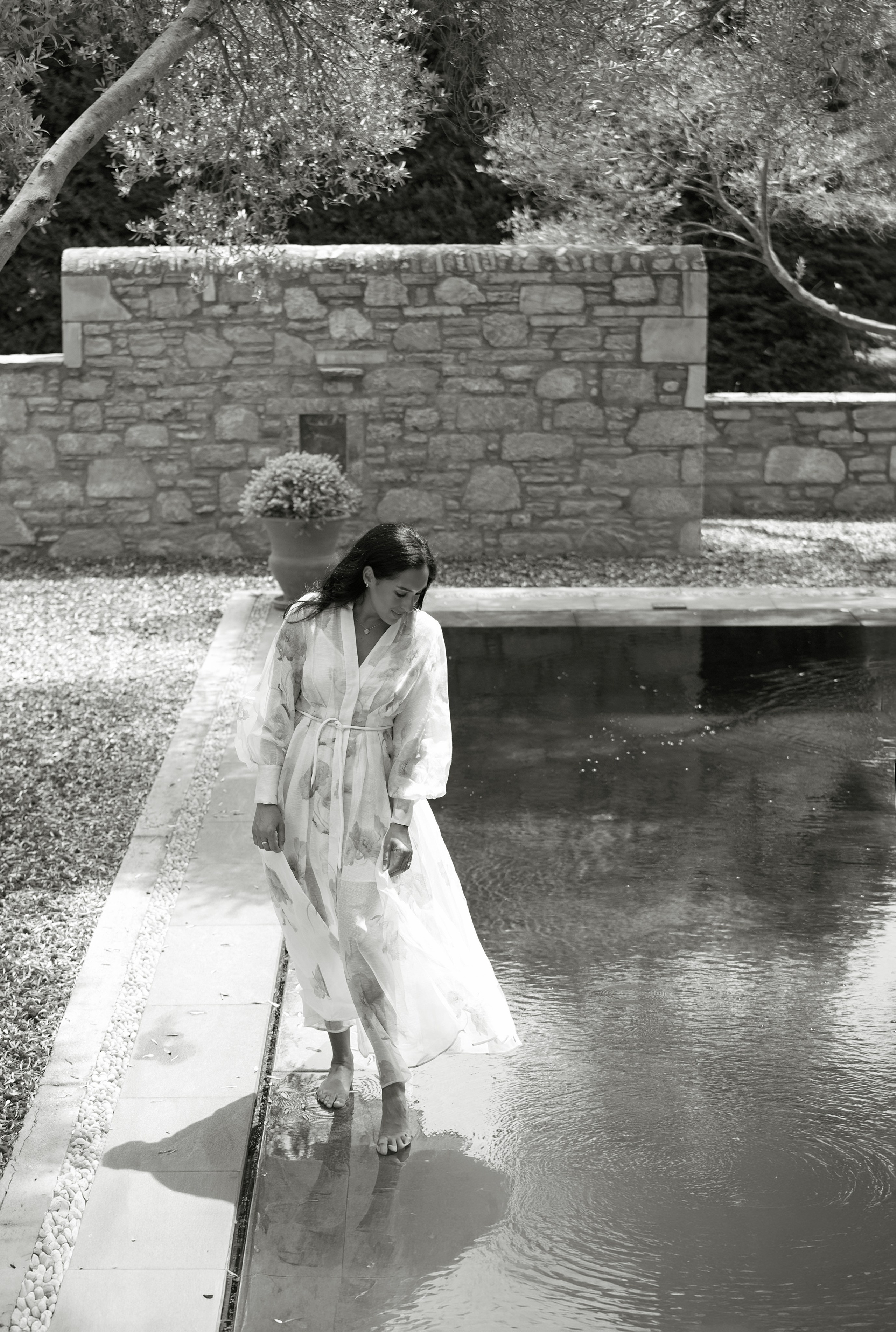 Woman walking barefoot by the water at Amanruya