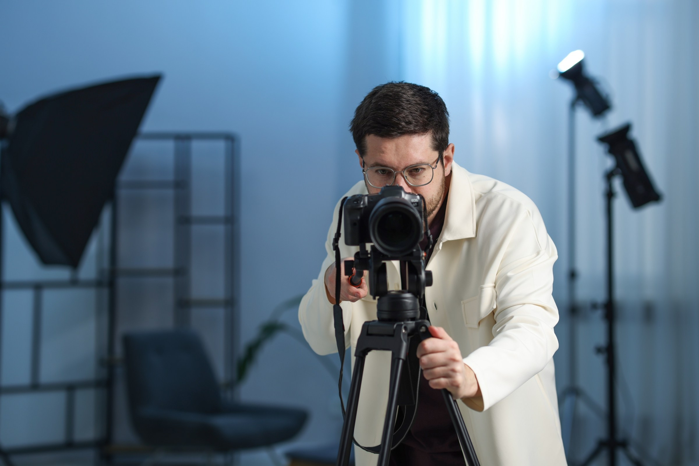 Видеограф снимает в студии на профессиональную камеру.