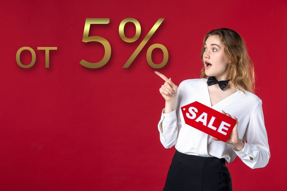 Молодая девушка с баннером "Скидка" в руках указывает на 5 процентную выгоду.
