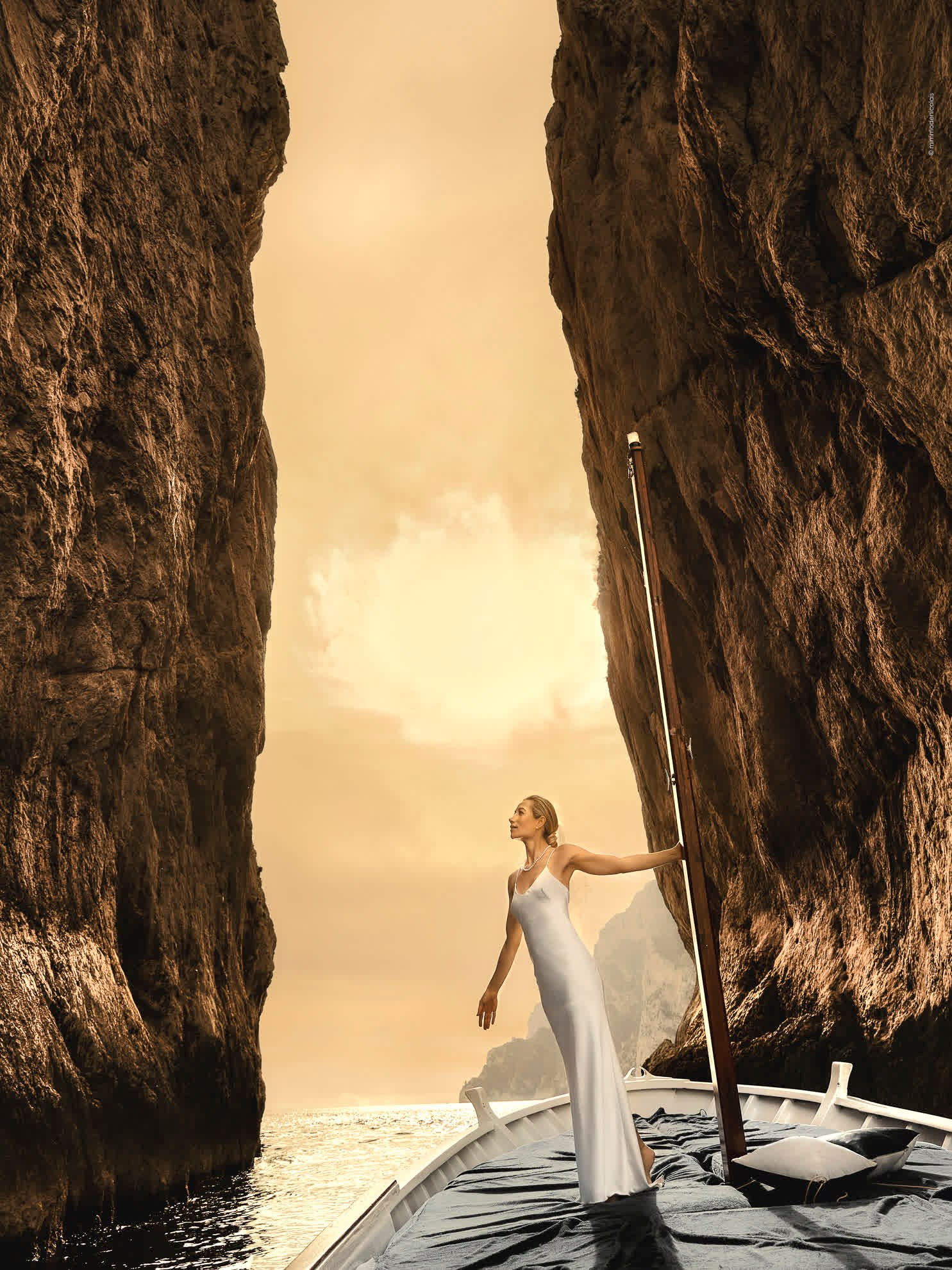 Top Italy weddings photography by Mimmo De Nicolais: A bride on a boat amidst the Faraglioni rocks, a visual poetry of Capri.