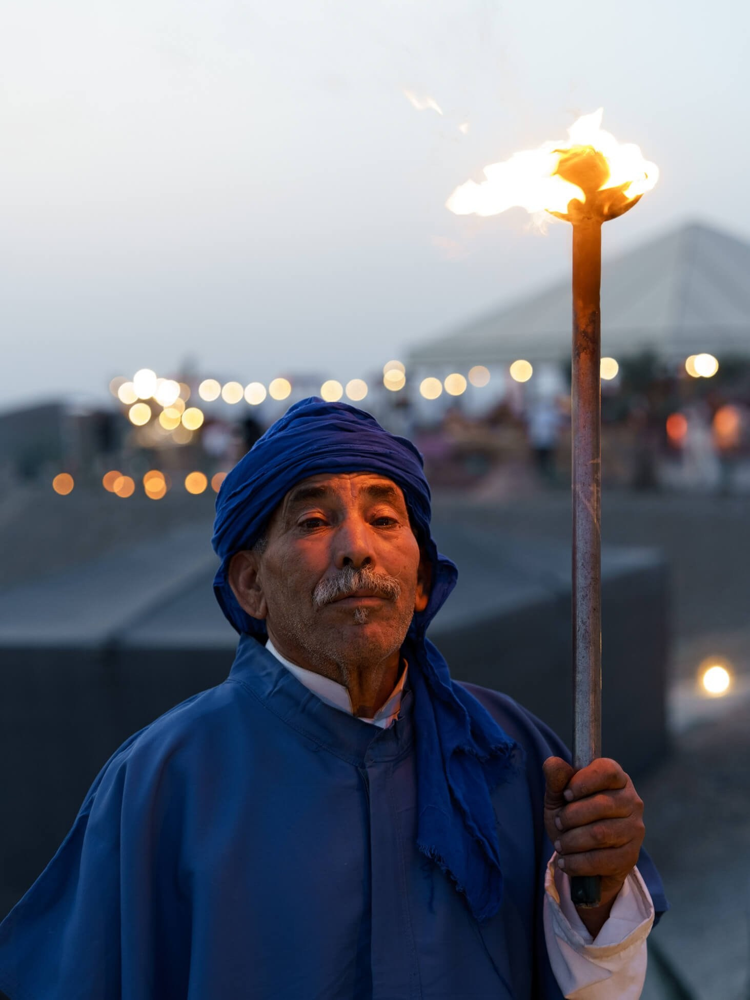 Torchbearer holding flame during luxury desert wedding reception, Morocco