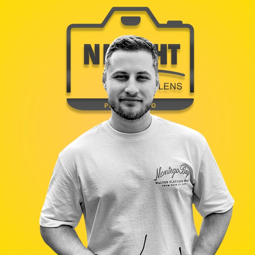 Portret profesional al unui bărbat pe fundal galben cu logo, expresie zâmbitoare